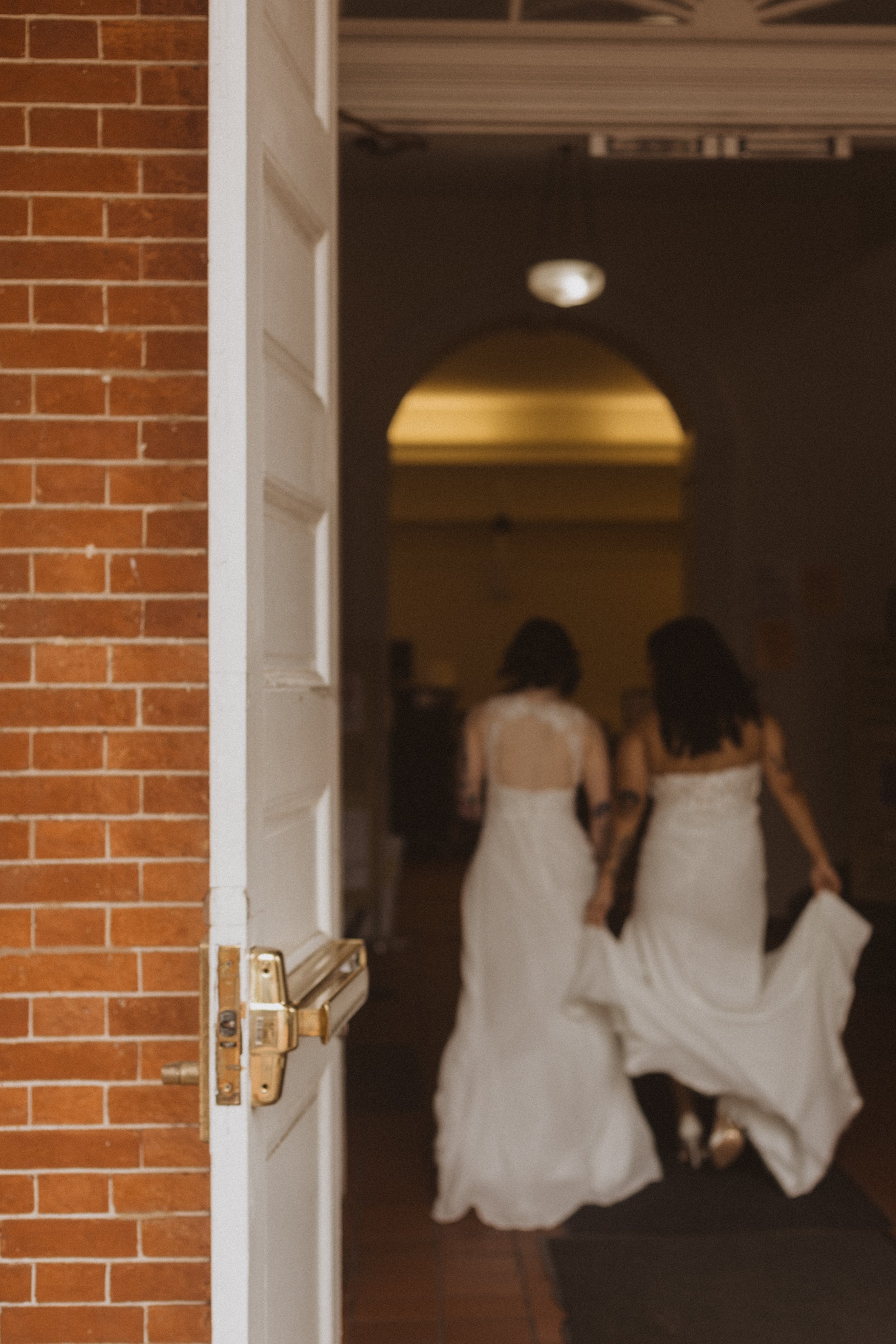 two brides walking in to the courthouse on their wedding day
