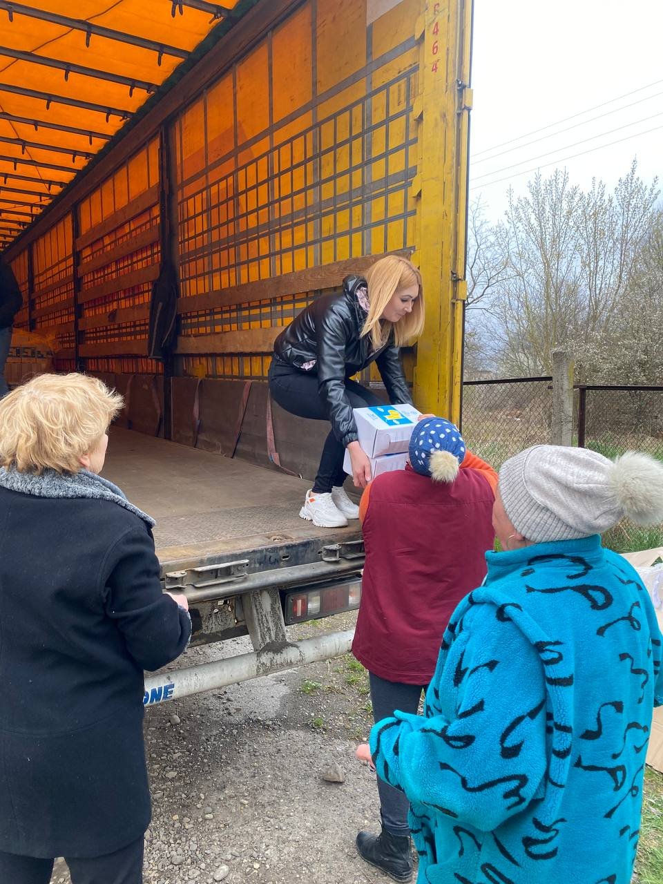 Elderly assisting unloading food shipment.JPG