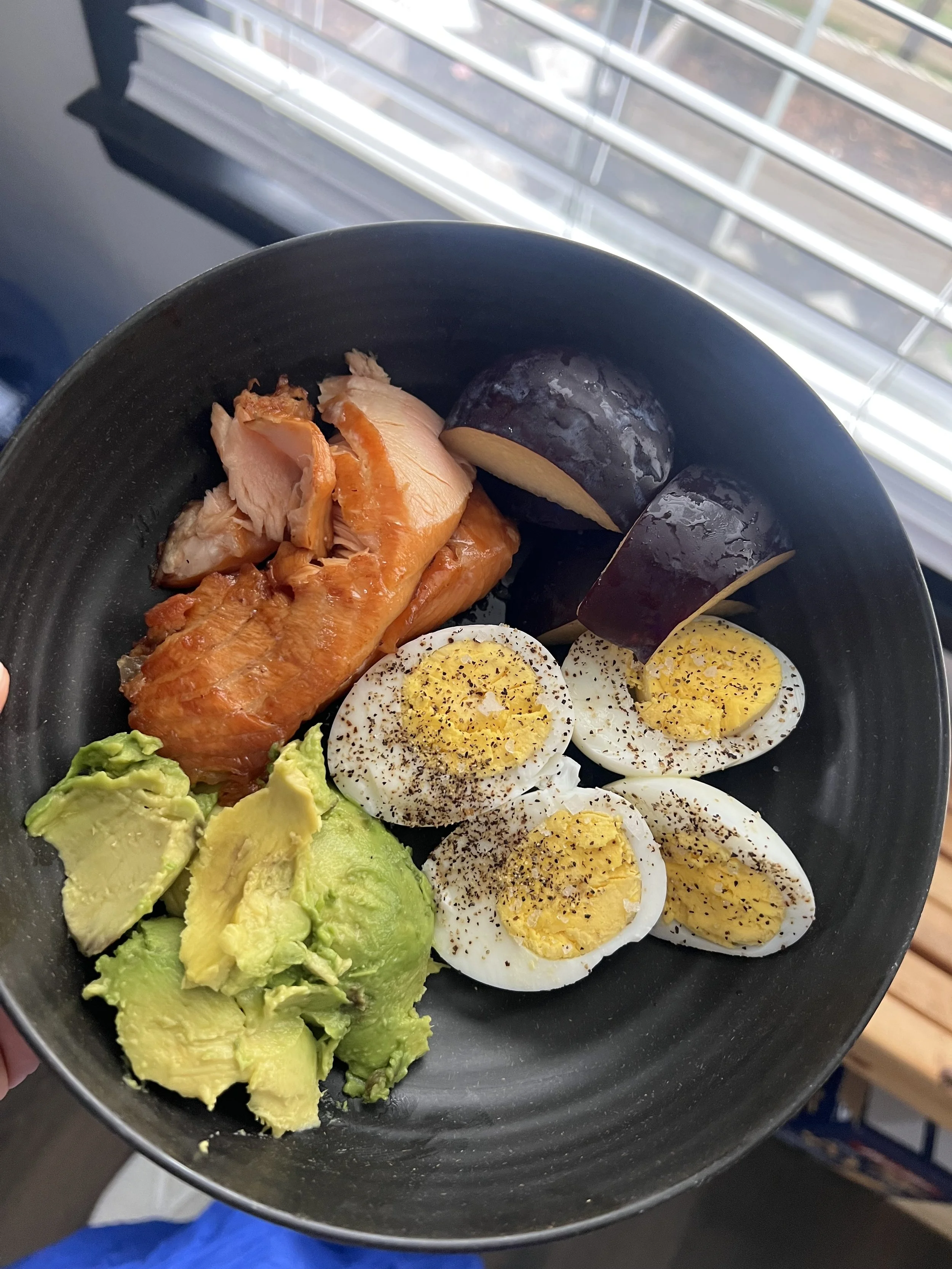 Salmon, boiled eggs, avocado, and plum