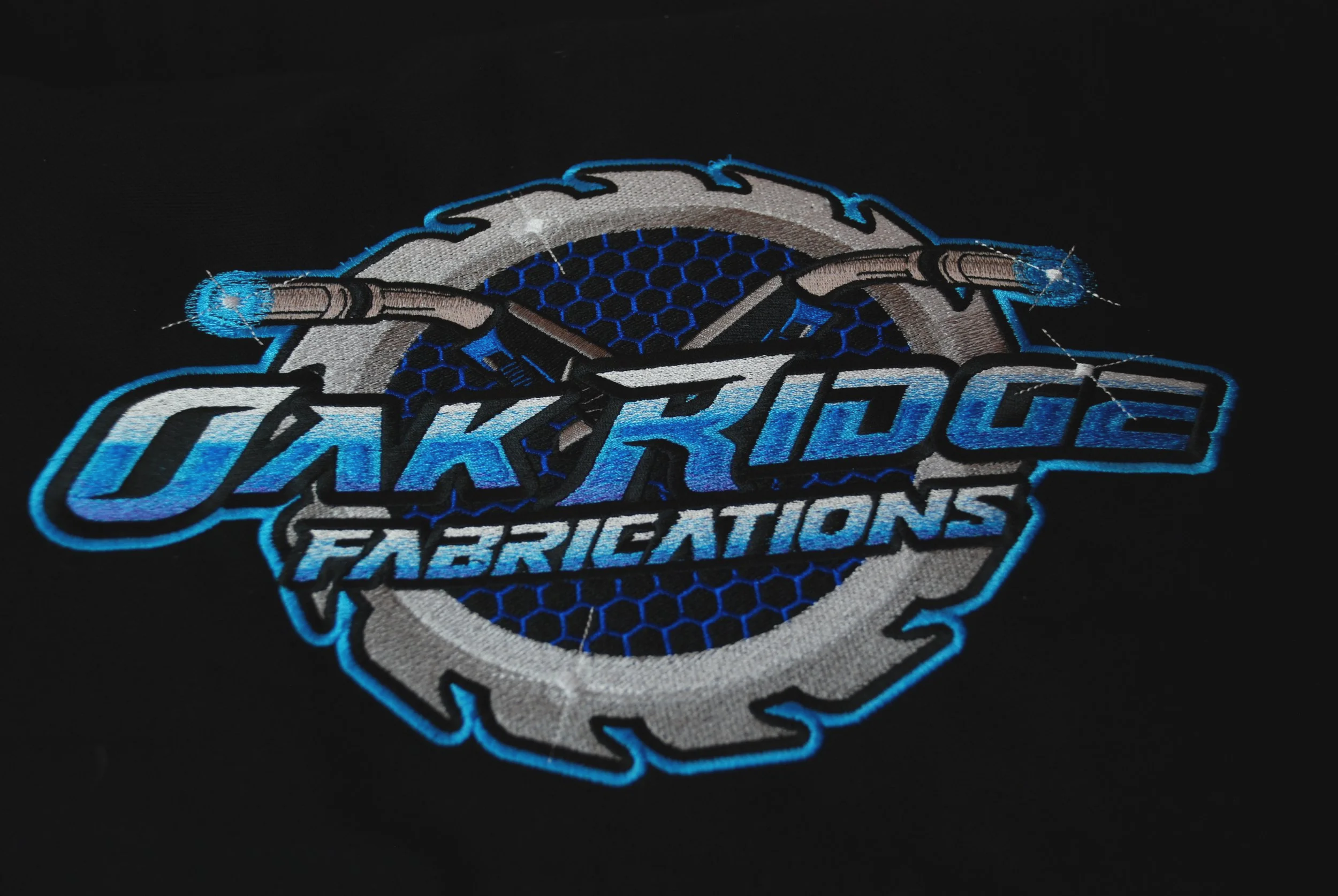close up of Oak Ridge Fabrications logo embroidered on black fabric