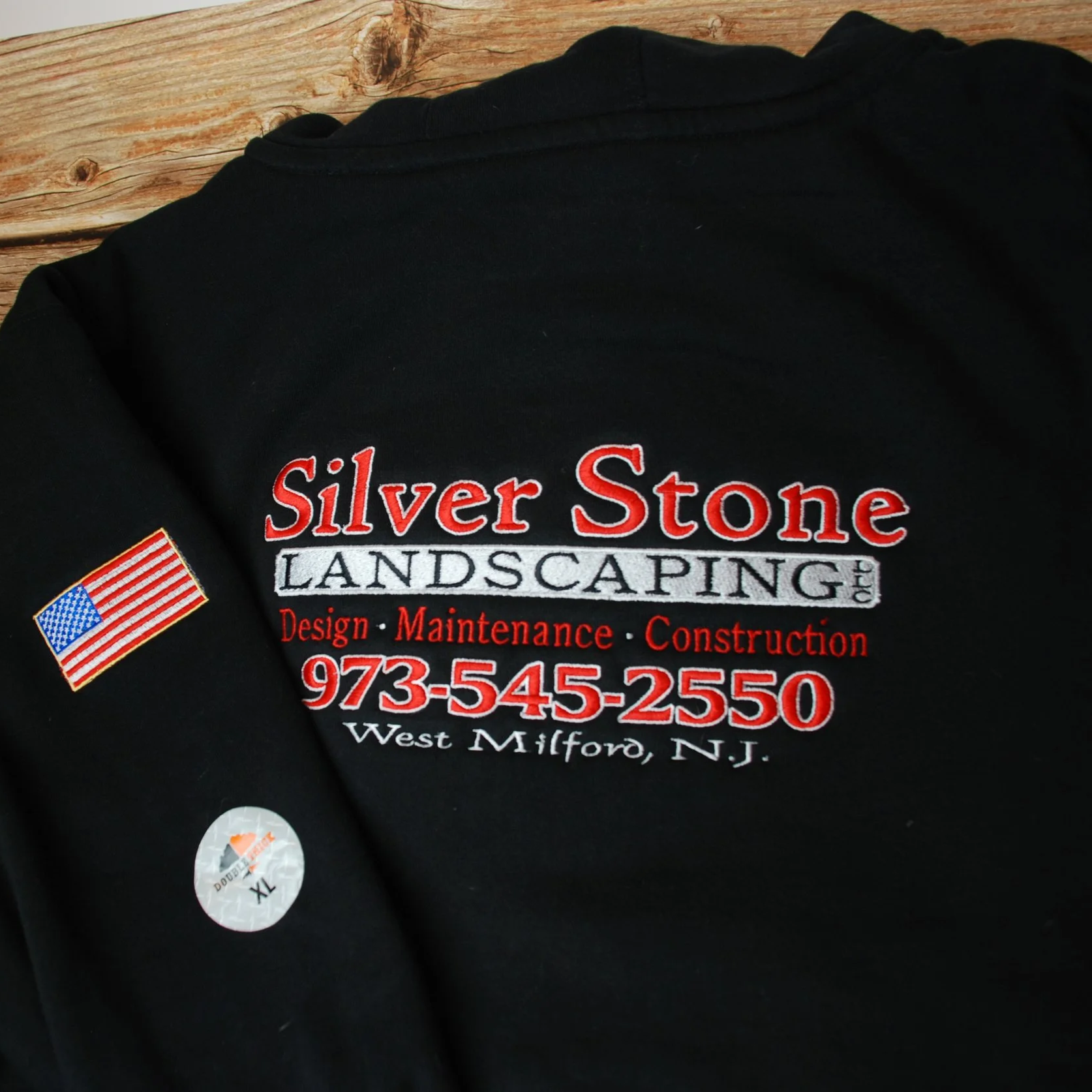 black sweatshirt with Silver Stone Landscaping logo embroidered on it and an American flag embroidered on the sleeve
