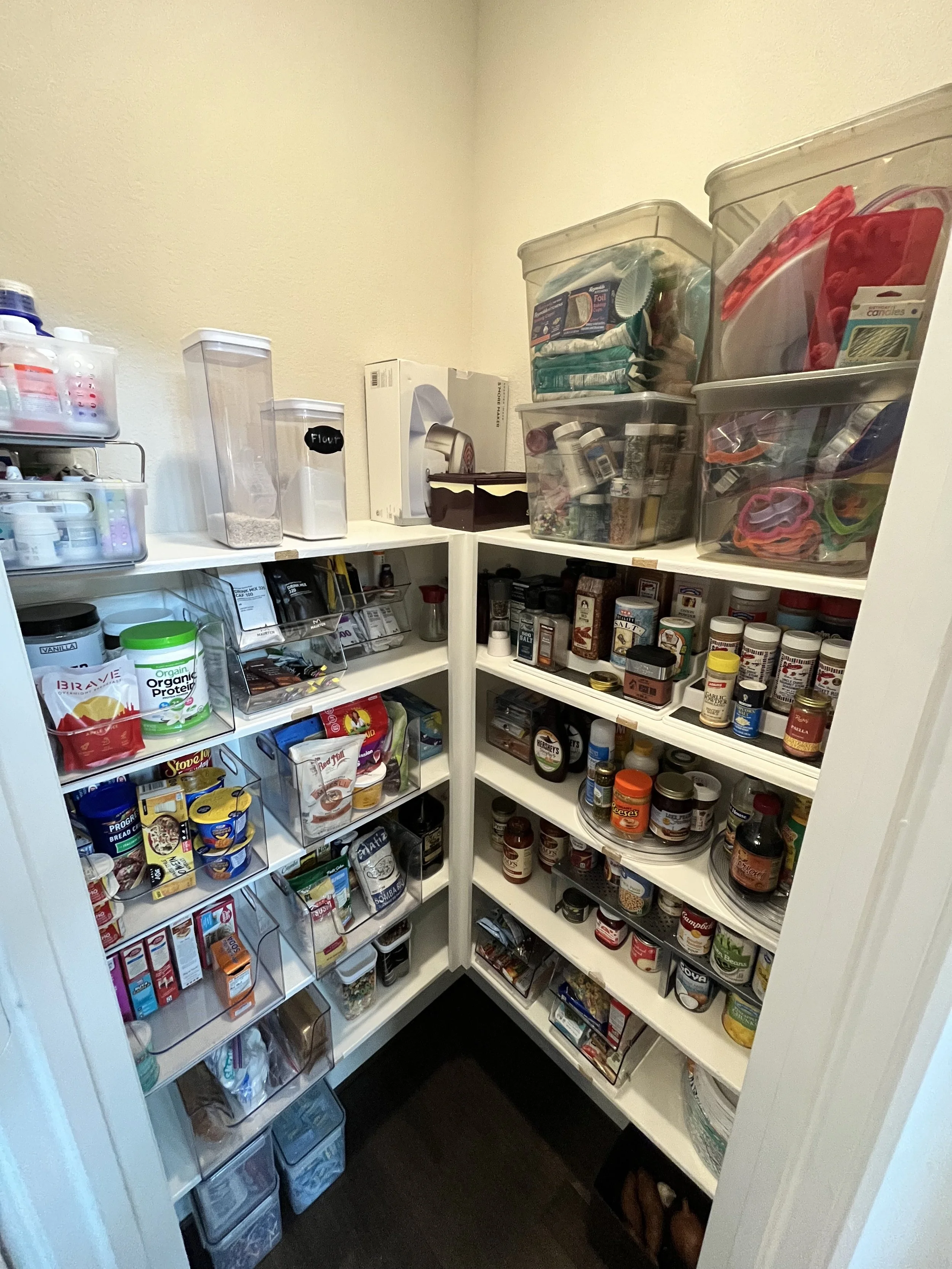 Clear containers, stored on the top shelf of a pantry, are perfect for storing holiday supplies or less frequently used kitchen items. 
