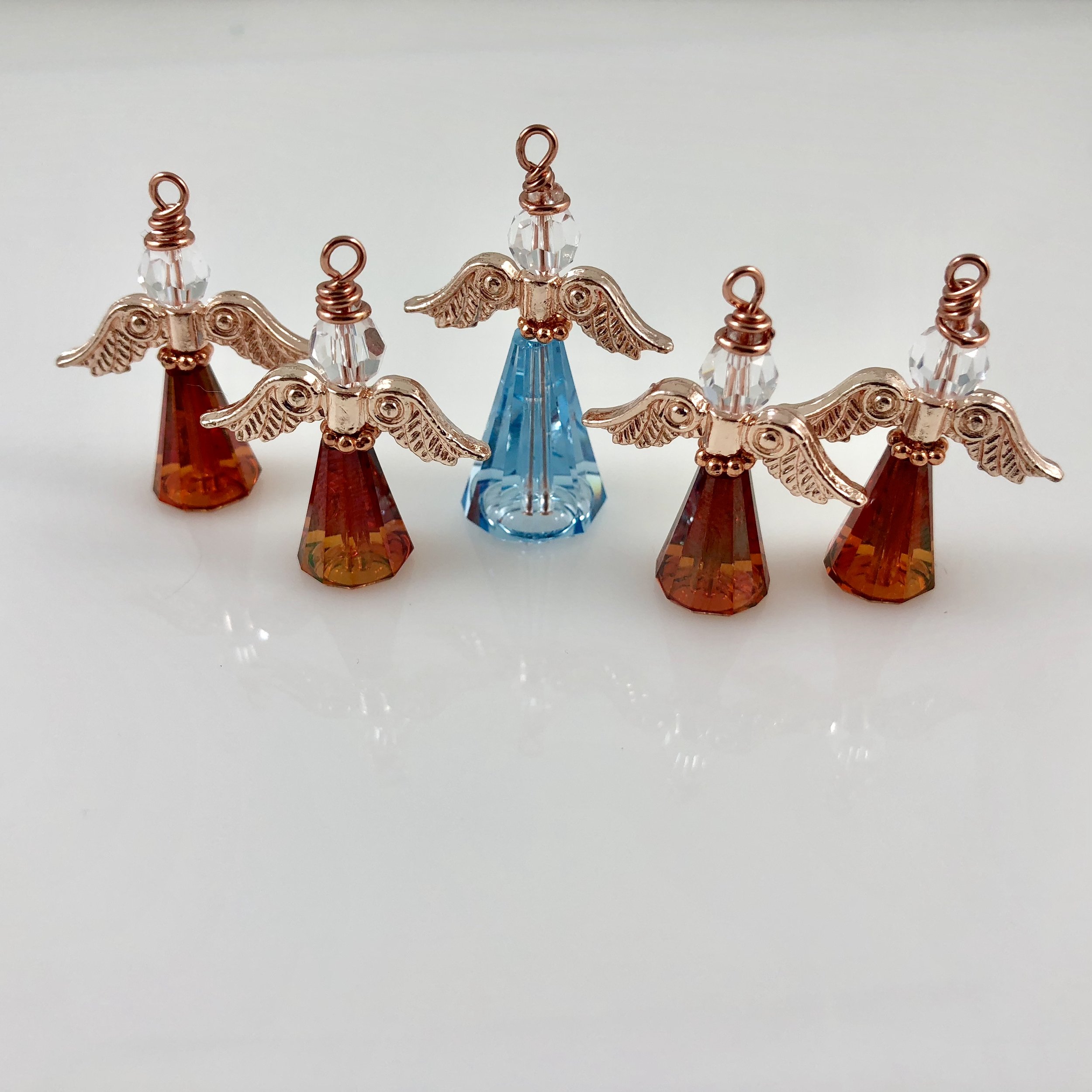 Large light blue angel and small red angels with rose gold wings