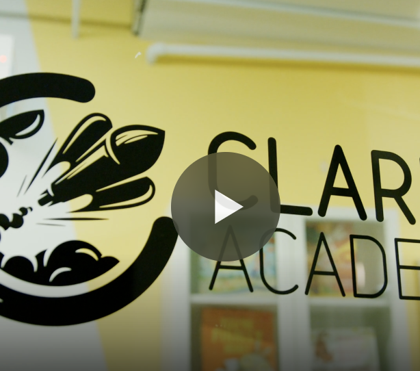 Part of a glass door with the text "Clear Academy" and a logo of a stylized face with hair made of paintbrushes.