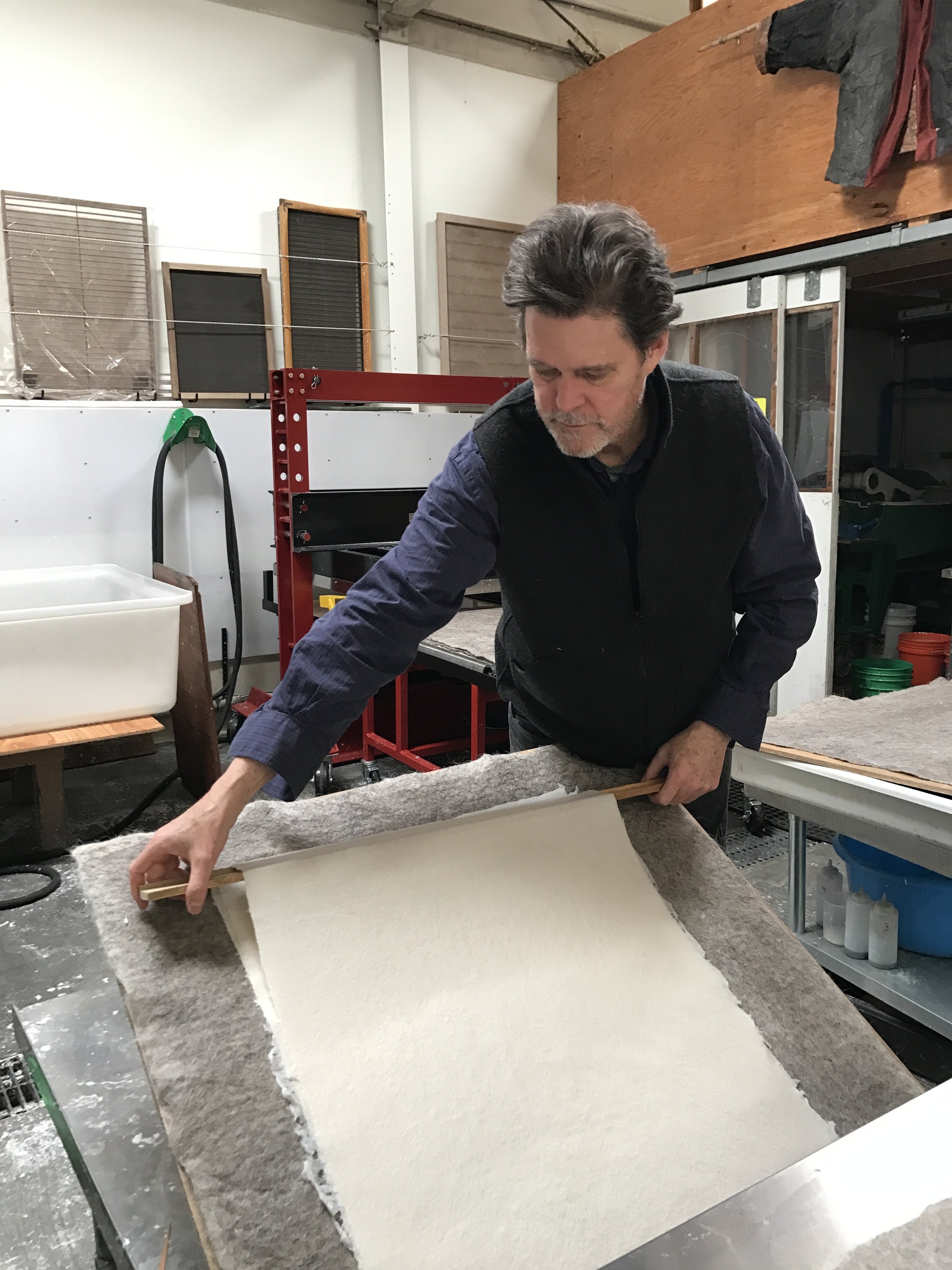 Donald Farnsworth lifting a formed and pressed sheet with wooden slice