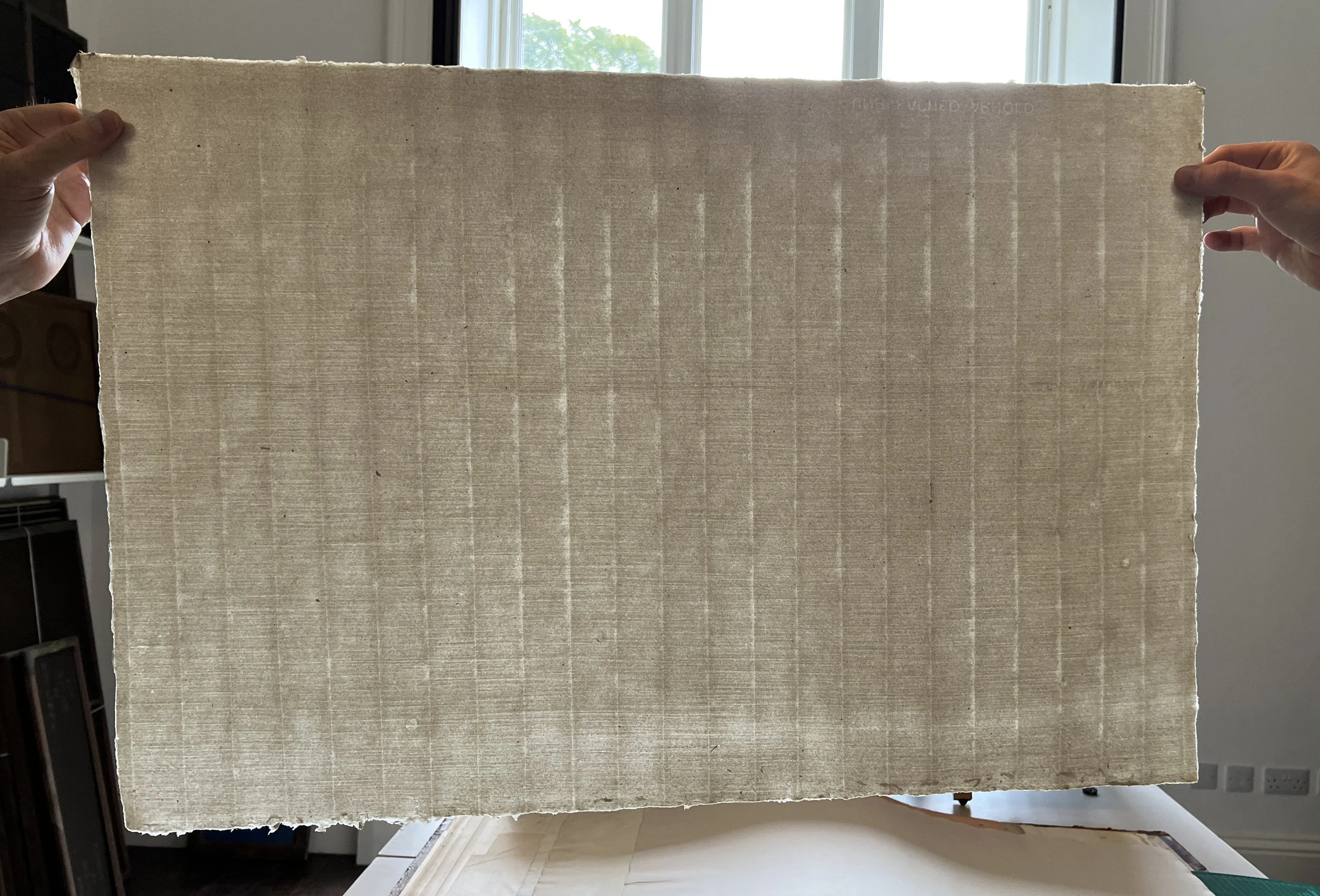 Slurred chain lines and thin across the "bad side" of the sheet (across the bottom - caused by a clogged screen). At The Paper Foundation, Kendal, UK 