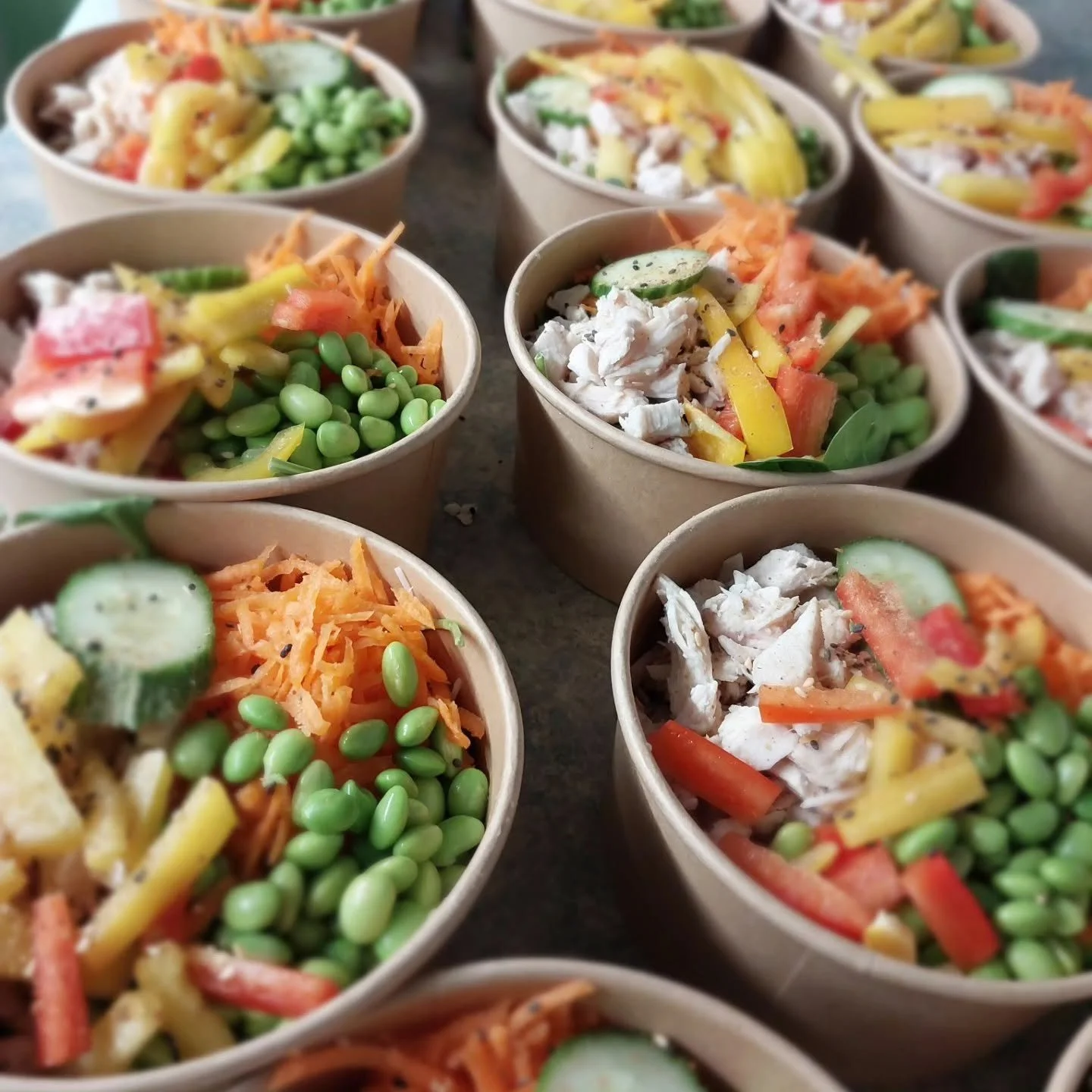Delicious, colourful chicken and edamame salad in paper bowls