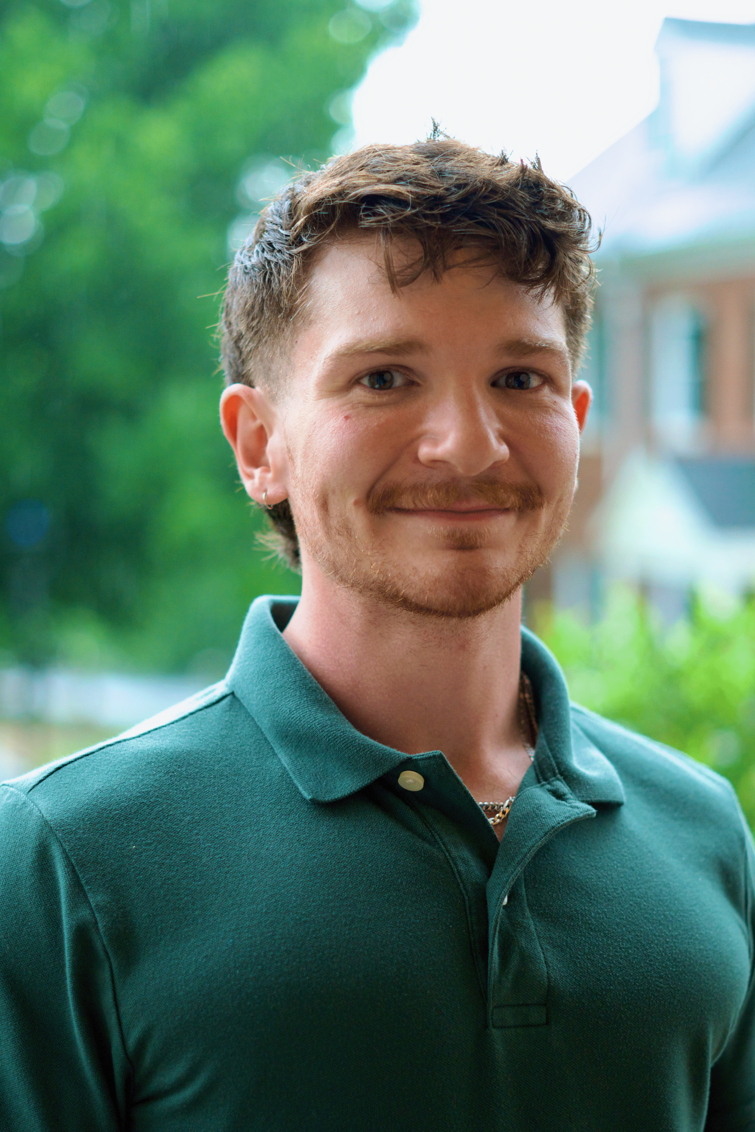 picture of young man with a beard and green collared shirt