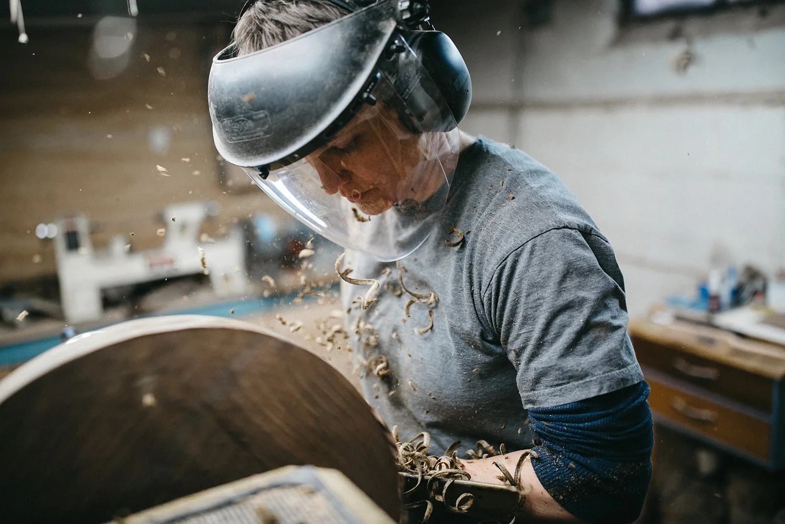 Branding photo of a woodworker carving wood on a lathe during a small business portrait session in Rochester, NY.