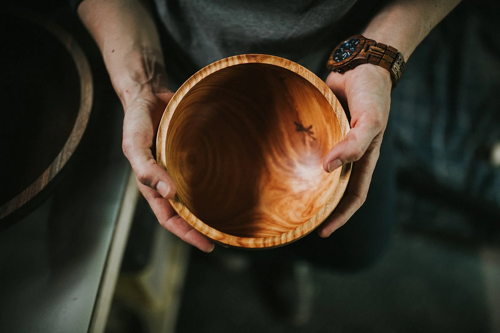 Artist holding a handmade wooden bowl during their business branding session in Rochester, NY.