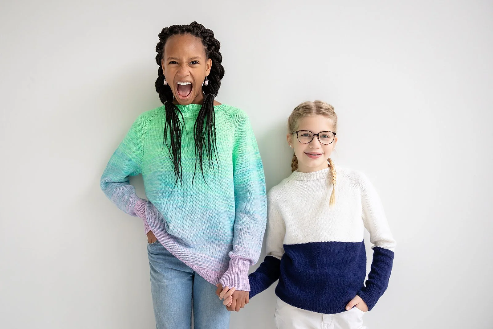 Two young sisters in hand knit sweaters during their family session in Rochester, NY. 