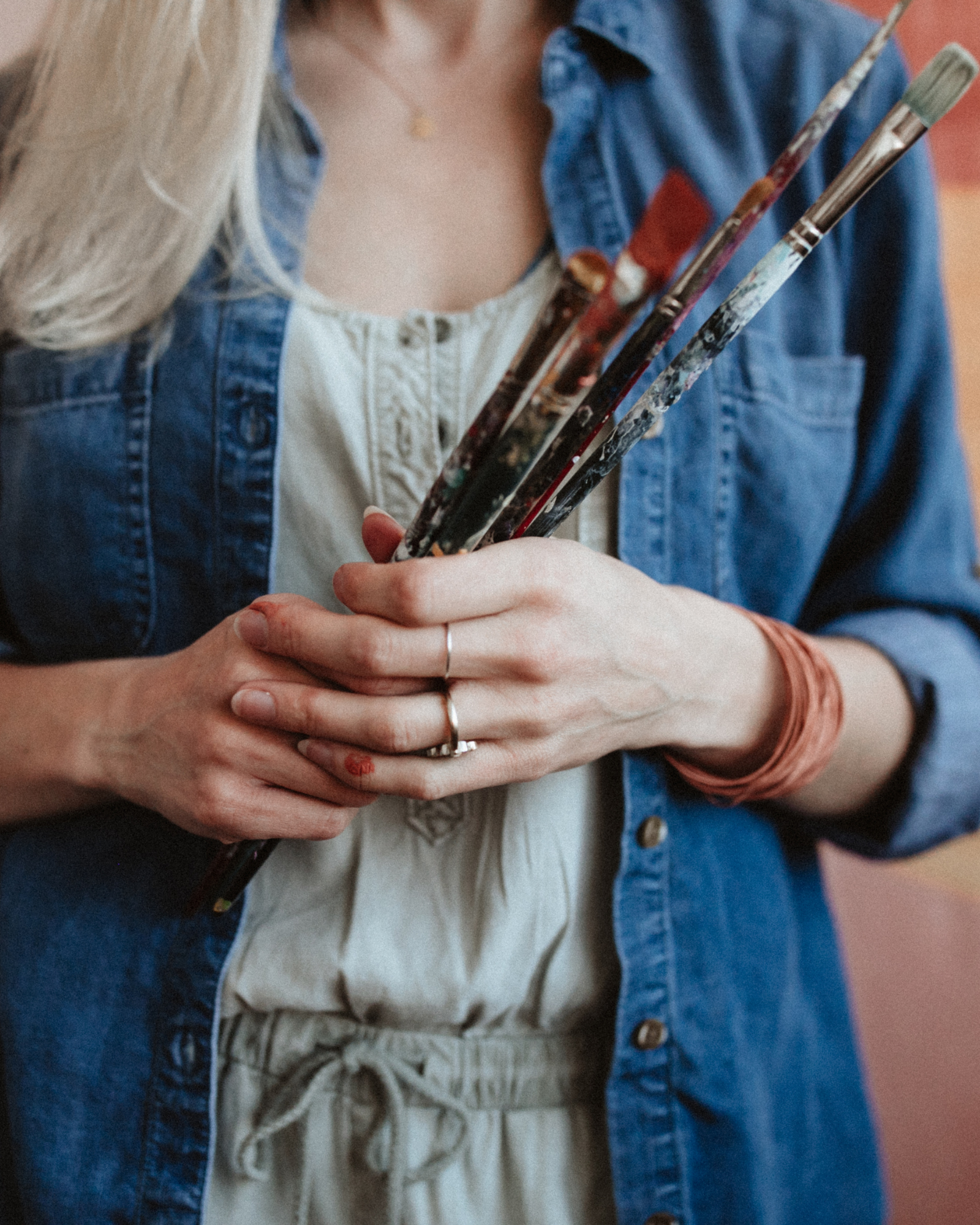 An artist holding her paintbrushes during a business branding session in Rochester, NY. 