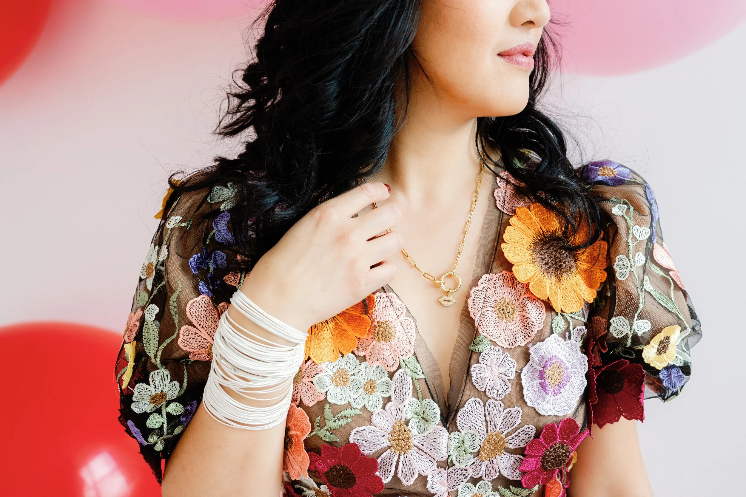 Jewelry product photo for Emerson & Oliver featuring layered necklaces and bangles styled on a model wearing a floral embroidered dress against a pink background.