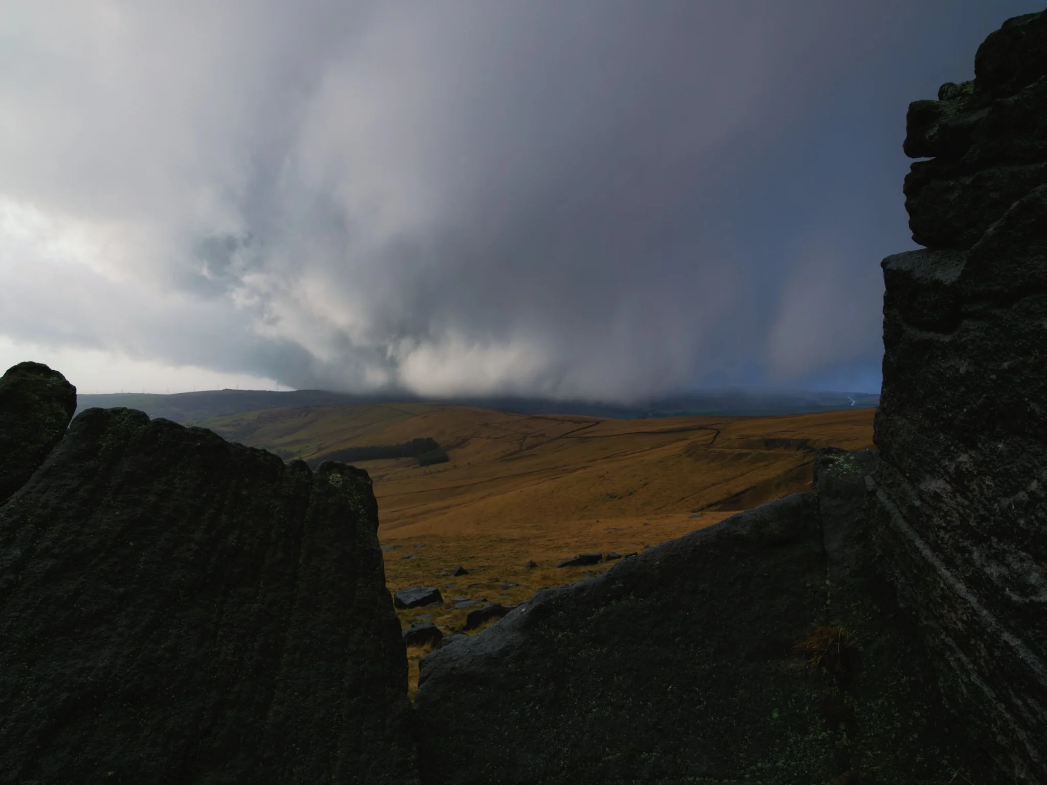 Dark storm clouds gathering over the rugged landscape of Marsden Moor during a winter wild camping trip.