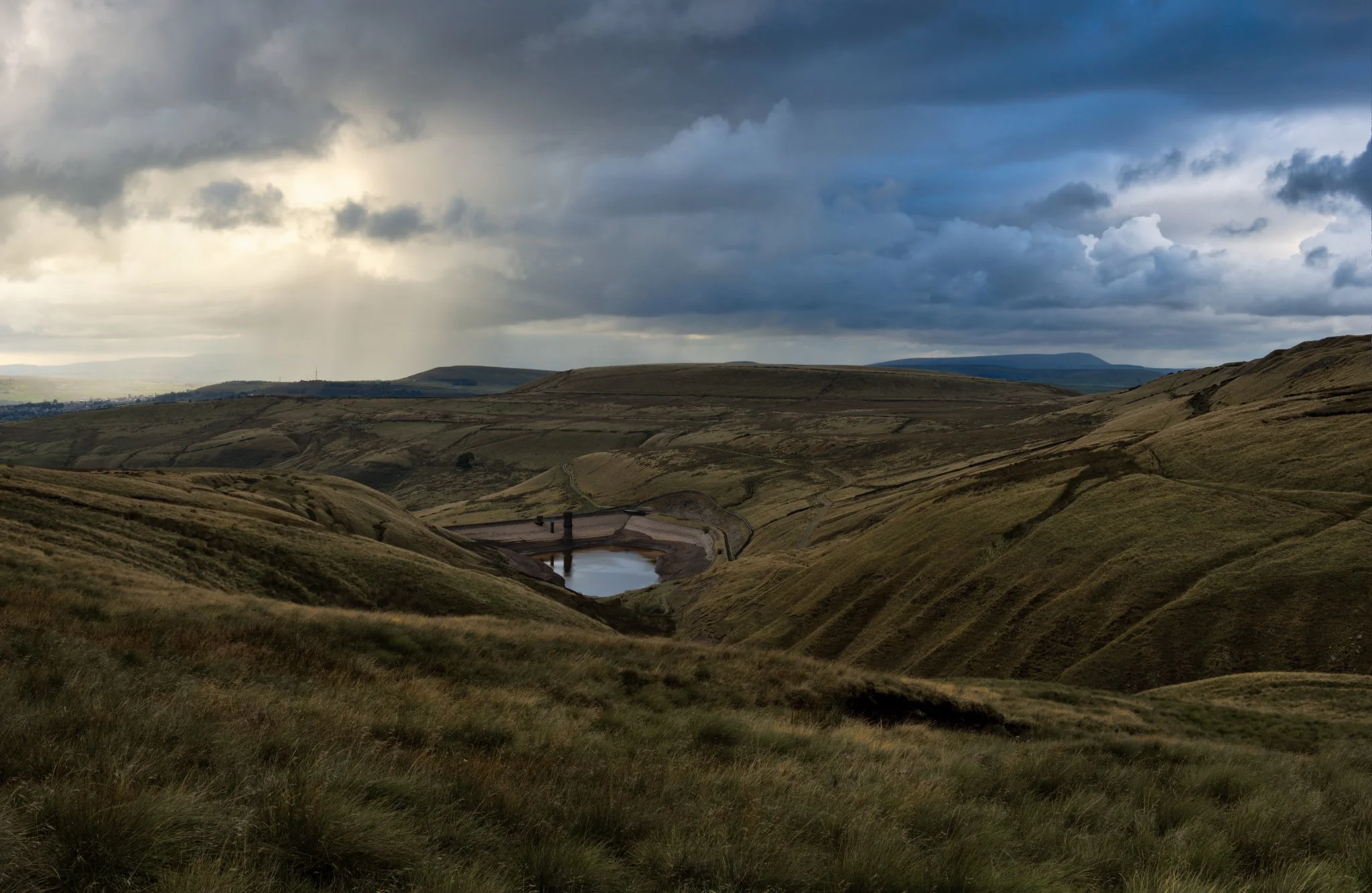 Scout Moor High Level Reservoir — another perspective showing the moor’s rugged edges beneath a sunset sky full of storm clouds.

