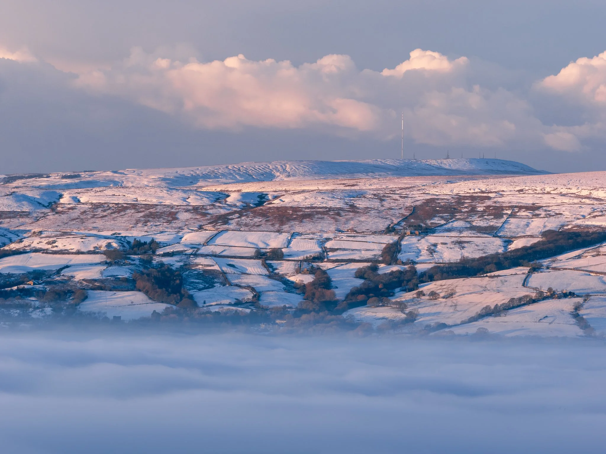 Fine art winter landscape photograph of fresh snow covering the rugged terrain at Cragg Quarry in the South Pennines.