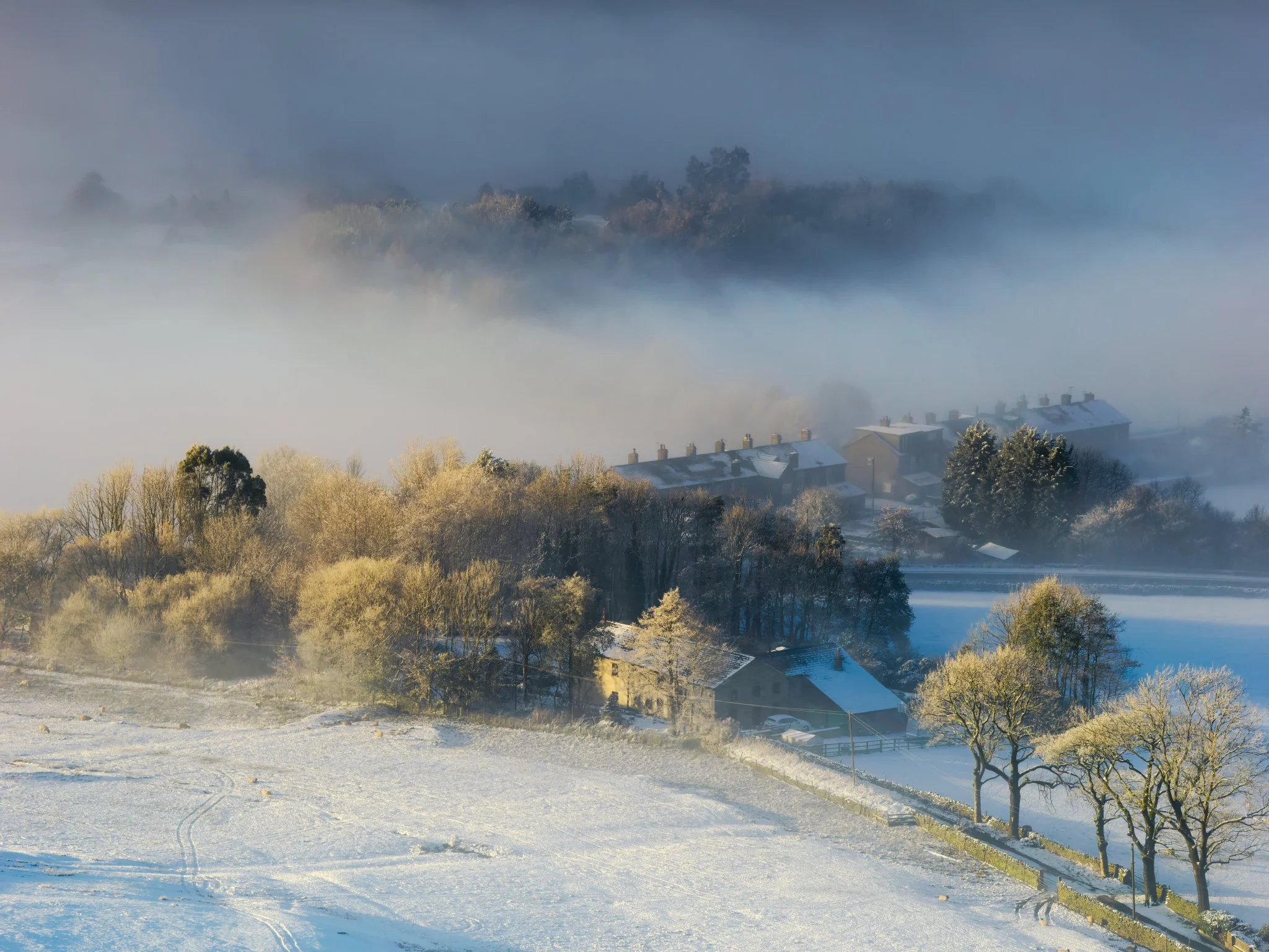 A picture postcard image of Turn Village in winter — a quiet rural village framed by hedgerows and fields under muted skies, imparting a sense of calm.