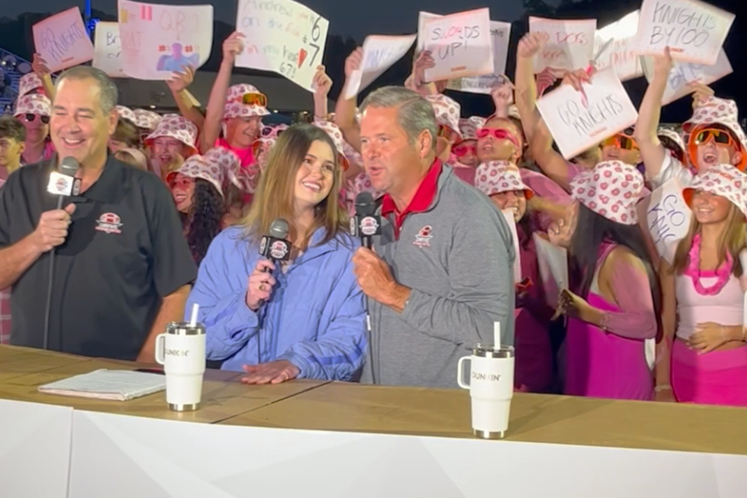Dunkin branded broadcast desk with pink-out student section