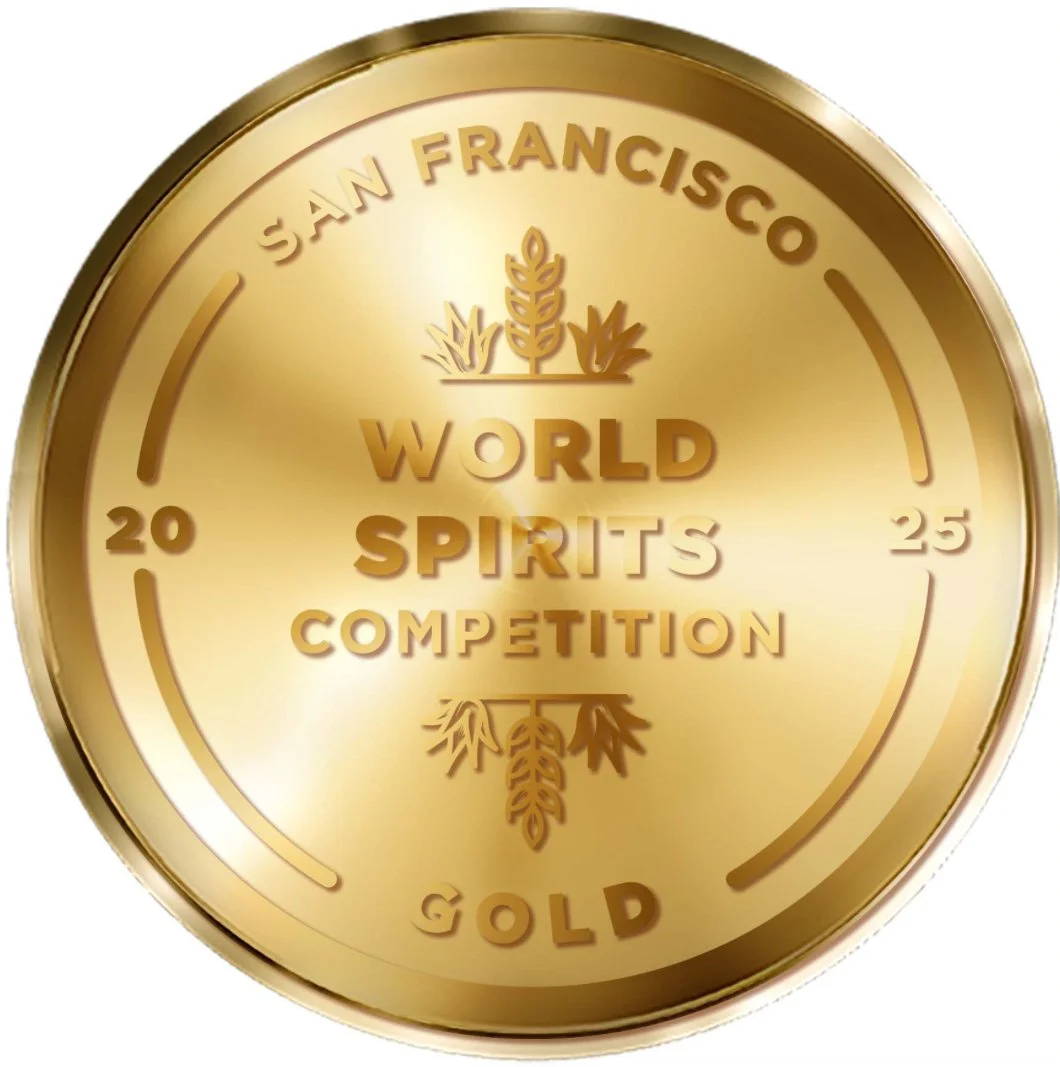 Golden medal or coin with inscriptions 'San Francisco,' 'World Spirits Competition,' and 'Gold,' with decorative wheat or barley illustrations.