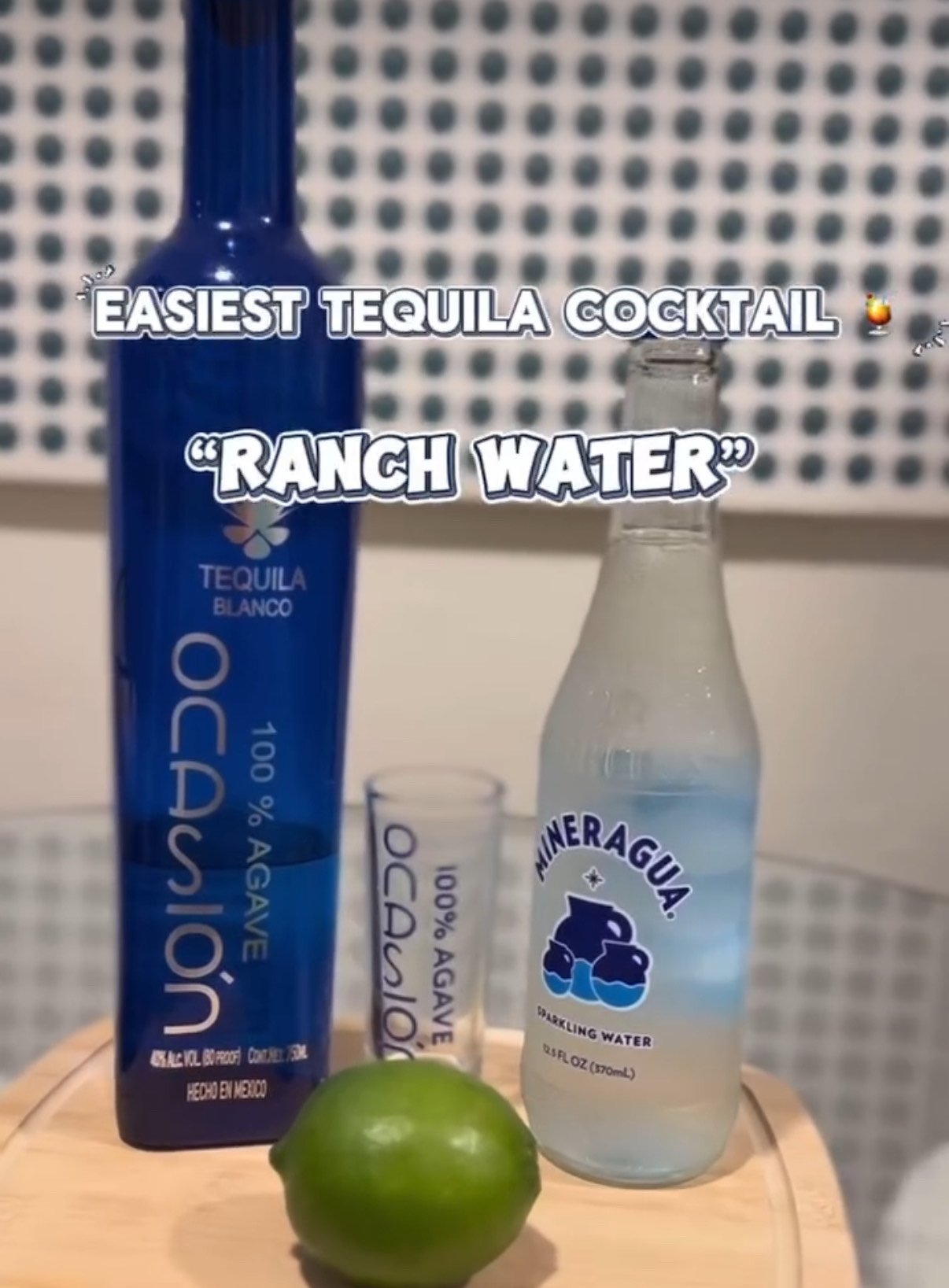 A bottle of tequila, a vial labeled 'O3,' a lime, a bottle of sparkling water, and a shot glass, with overlay text reading 'Easiest tequila cocktail: Ranch Water.'