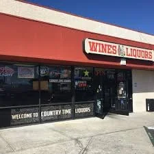 Exterior of a liquor store with a red awning and a sign that reads 'WINES & LIQUORS'