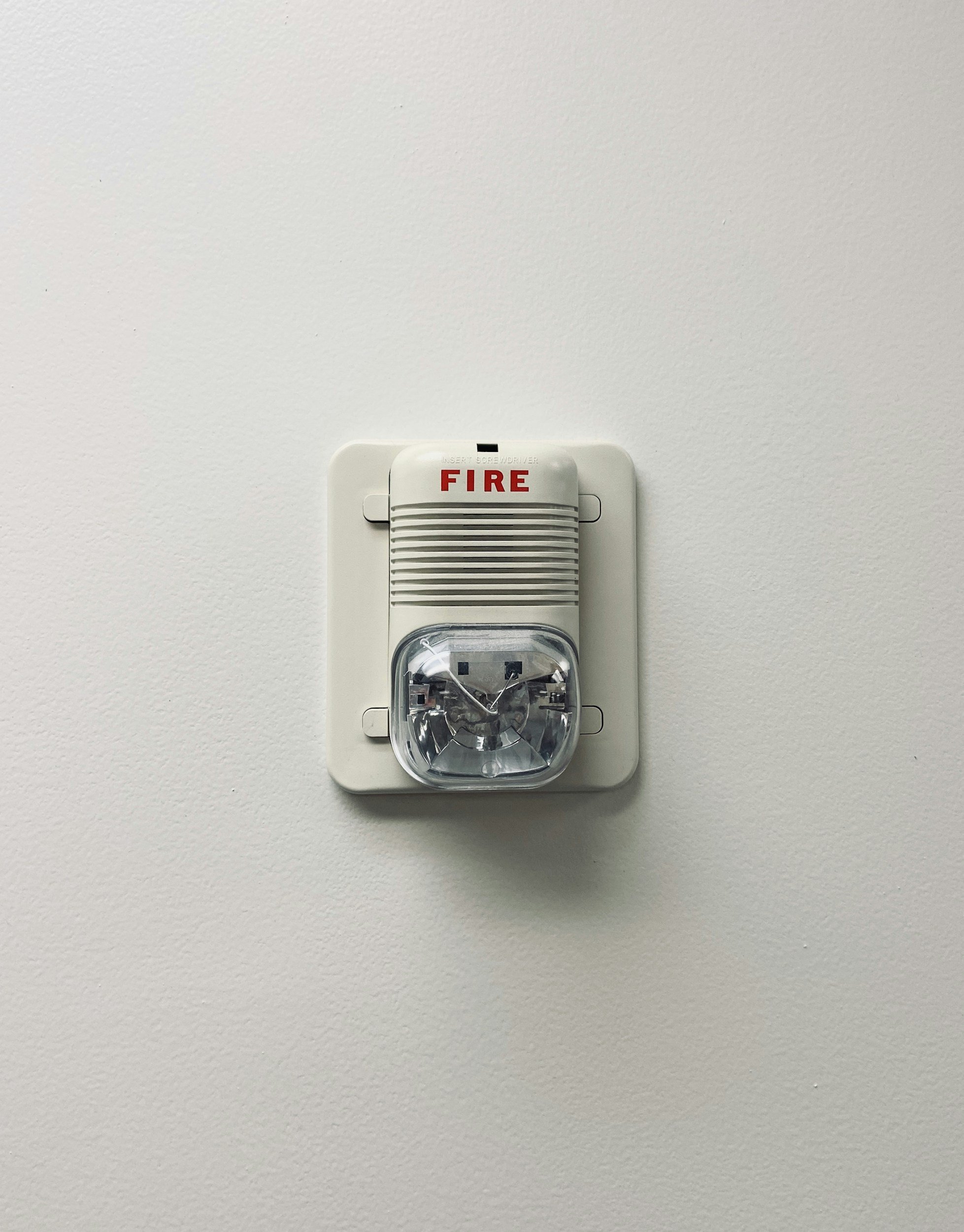 Fire alarm mounted on a white wall.