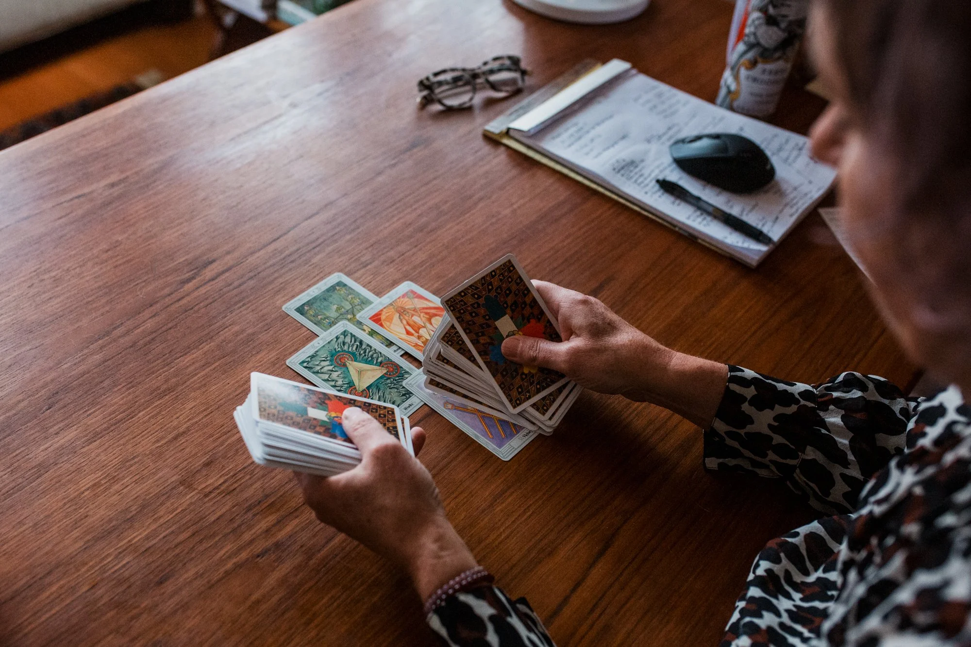 Tarot reader flipping cards over at desk