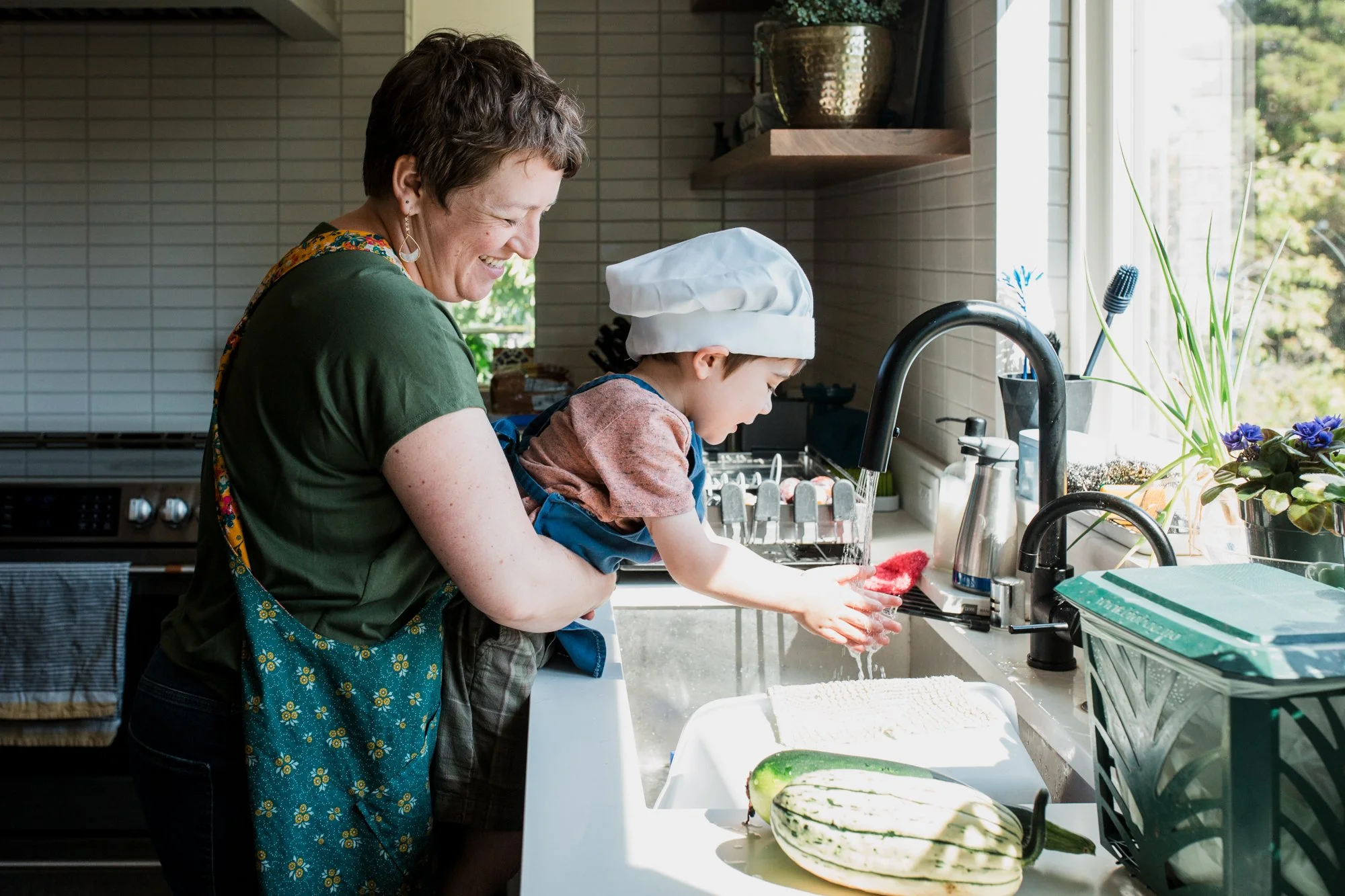 Mom and son wash hands in kitchen after baking in their Greenwood, Seattle home