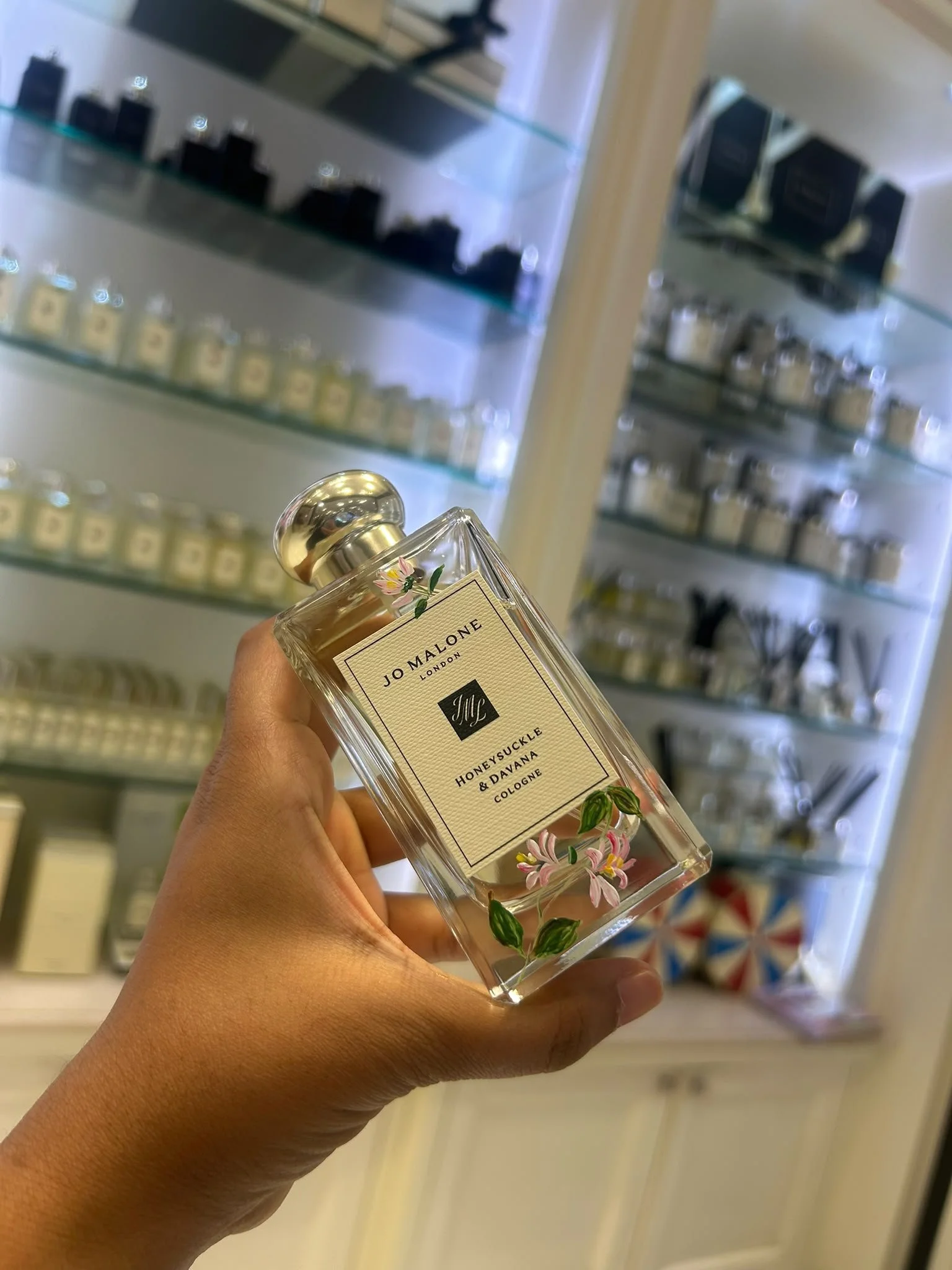 Hand-painted Jo Malone fragrance bottle with custom floral artwork for a luxury retail brand activation.
