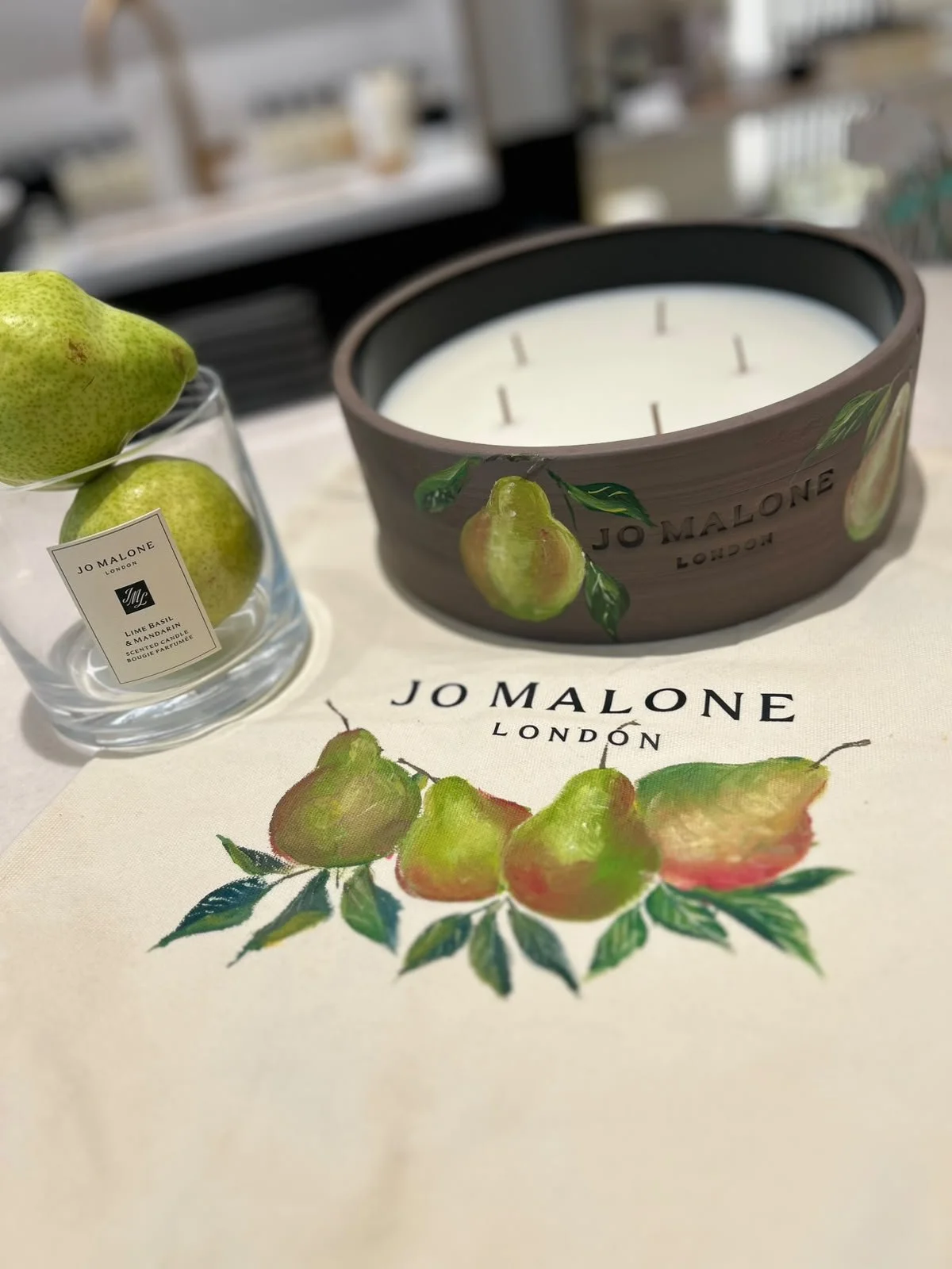 Live bottle painting artist customizing a Jo Malone fragrance bottle during a luxury retail brand activation and customer engagement event in Detroit.