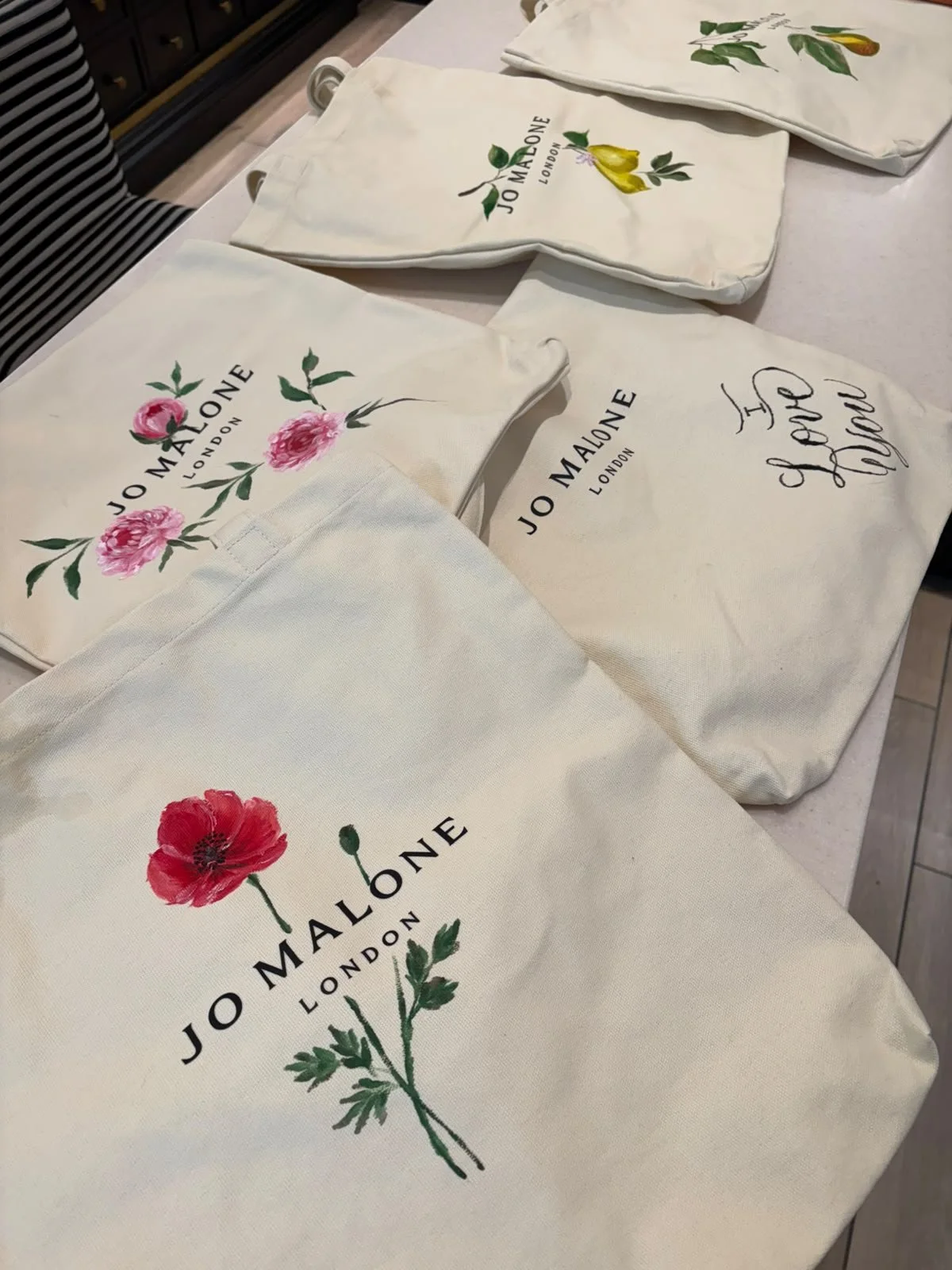 Hand-painted Jo Malone bag with custom floral artwork for a luxury retail brand activation.