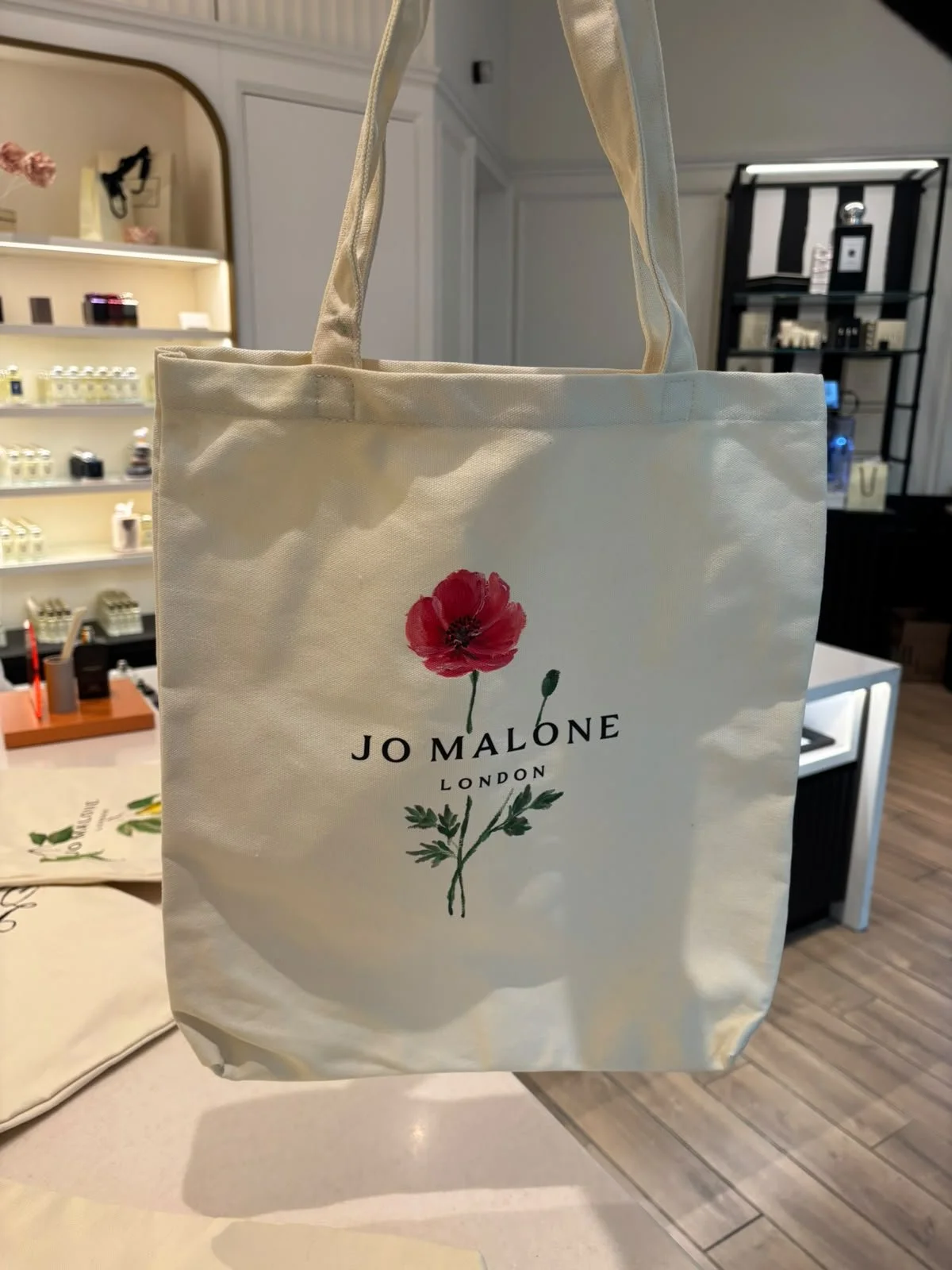Hand-painted Jo Malone bag with custom floral artwork for a luxury retail brand activation.