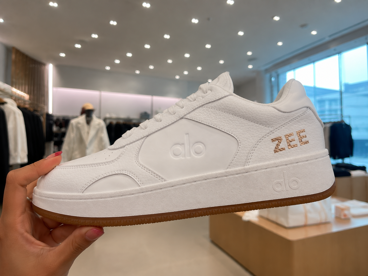 Custom personalized ALO Yoga sneaker featuring gold initials created by a live personalization artist during a luxury retail brand activation and experiential marketing event.
