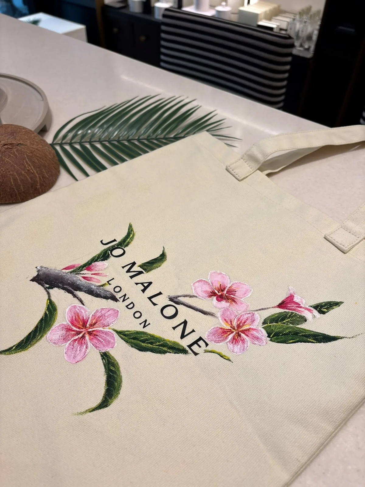Hand-painted Jo Malone bag with custom floral artwork for a luxury retail brand activation.