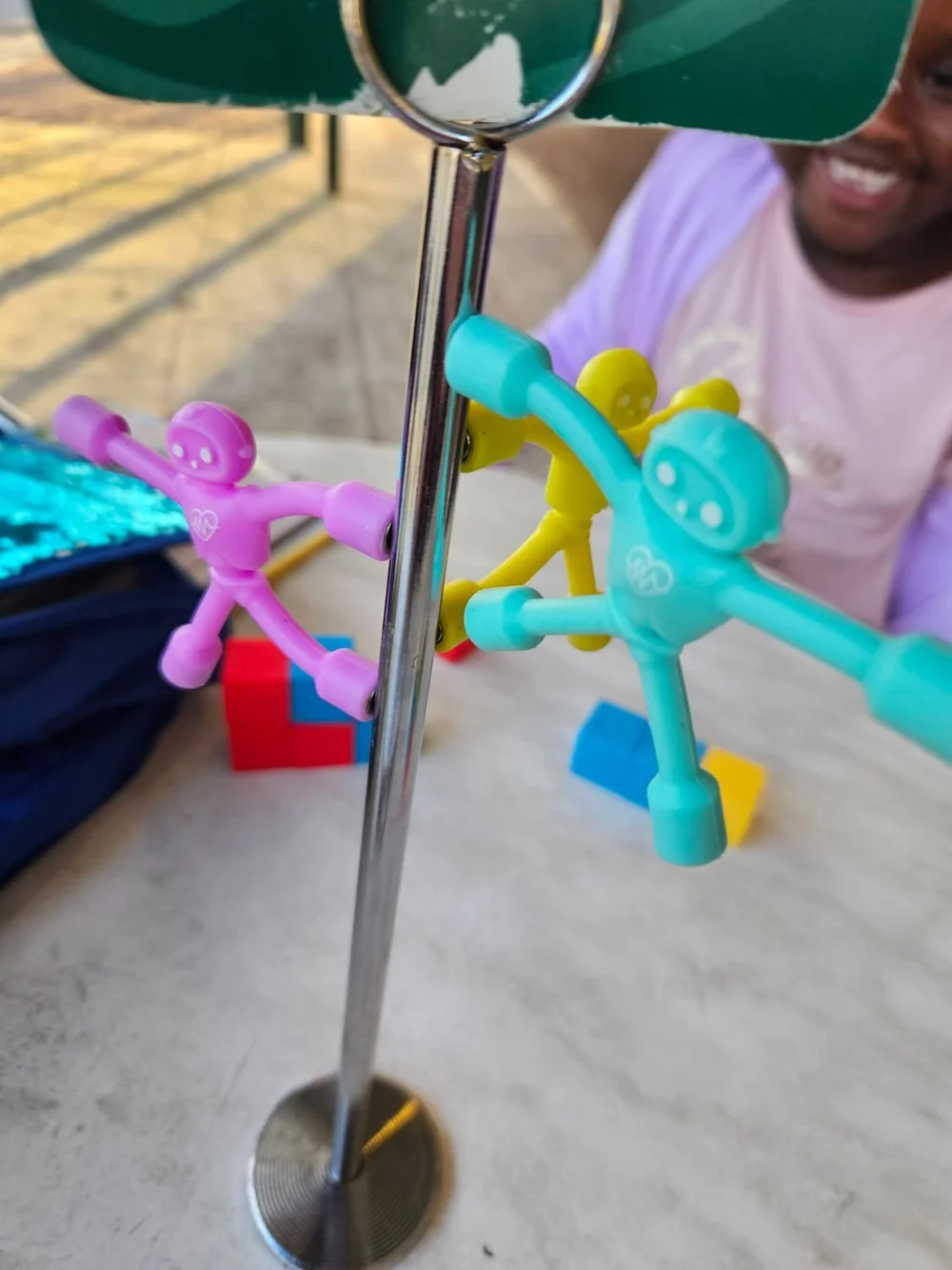 Magnet people stuck to a metal table stand at a cafe