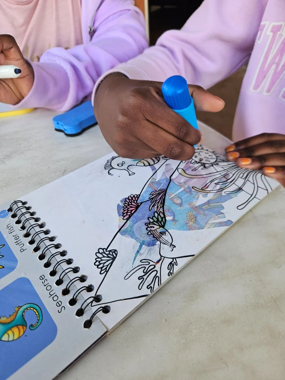 A child colouring the water magic book with the water pen