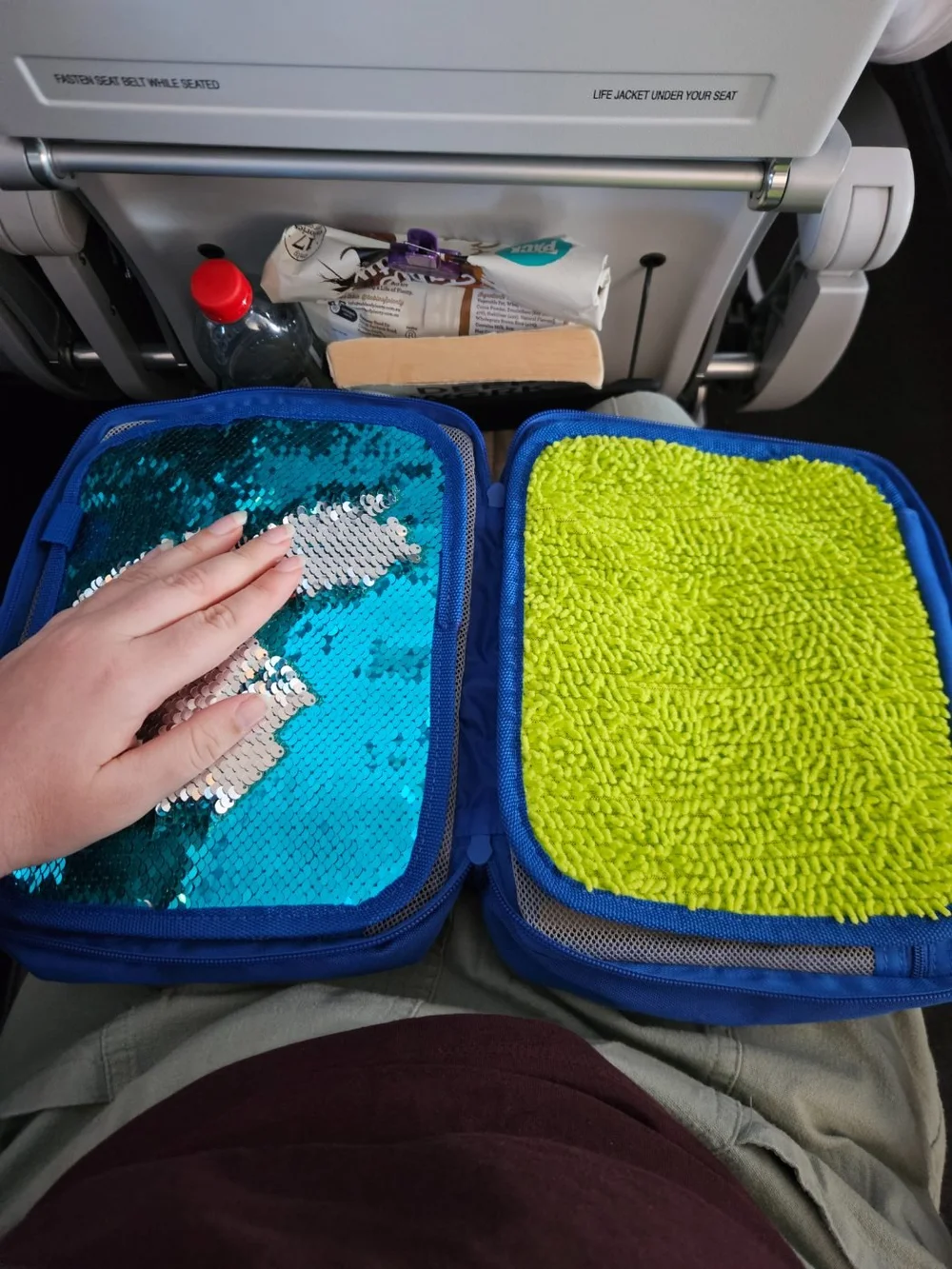 A hand sweeping the sequin panel on the kit mid-flight