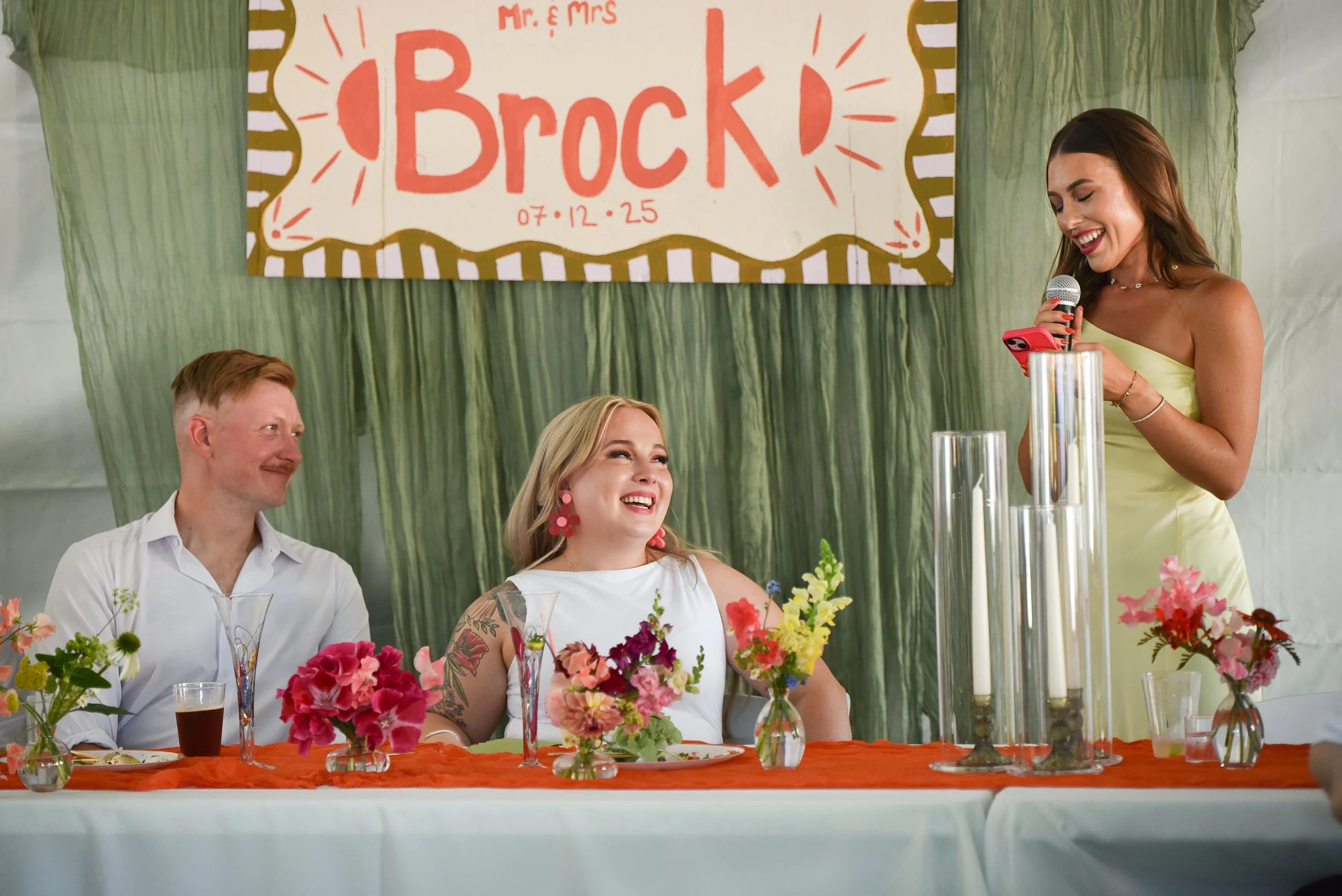 Wedding party table with candles and bud vase bouquets.