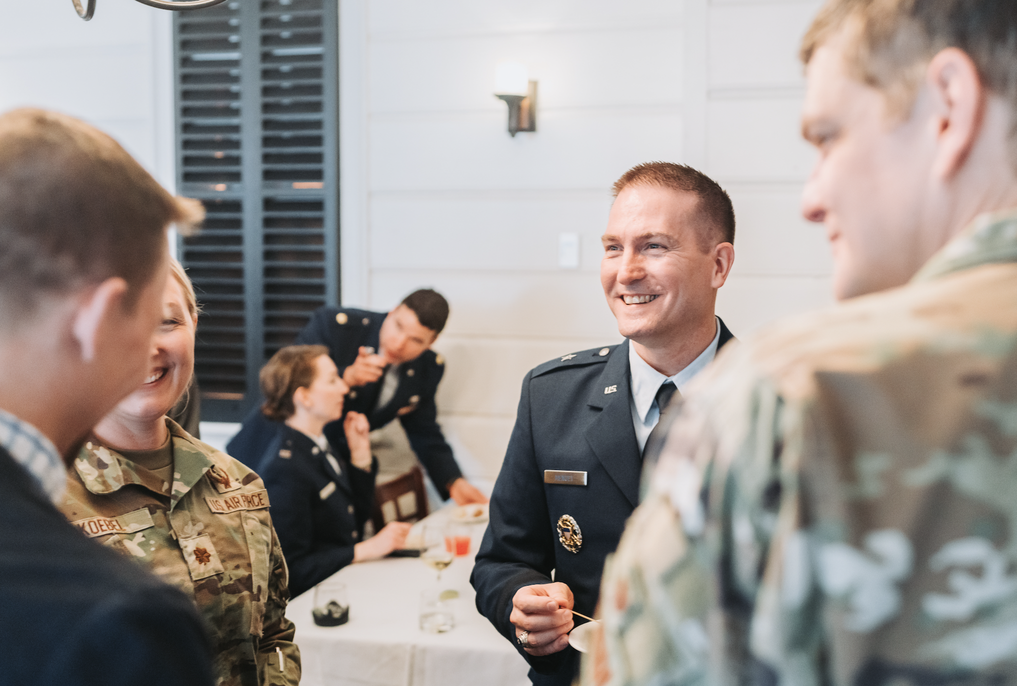 Group of military personnel socializing at an event in uniform.