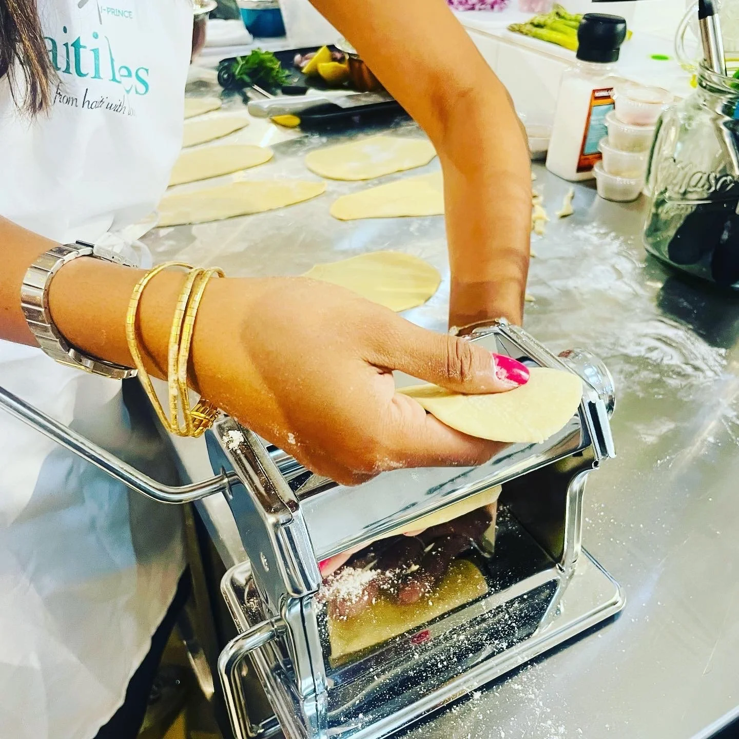 Person making pasta dough using a pasta machine on a countertop
