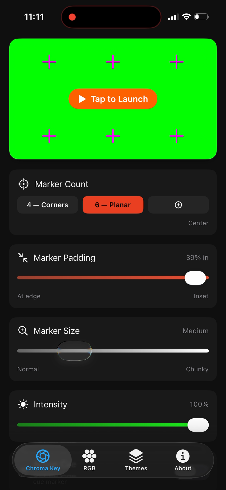 A smartphone screen displaying an app with a green background, purple crosses marking points, and a large orange button labeled 'Tap to Launch'. Below, settings include marker count, marker padding, marker size, and intensity, along with navigation icons at the bottom labeled Chroma Key, RGB, Themes, and About.