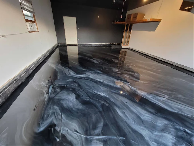 Empty room with black and white marbled epoxy flooring, white and dark walls, a window, a door, and a floating wooden shelf.