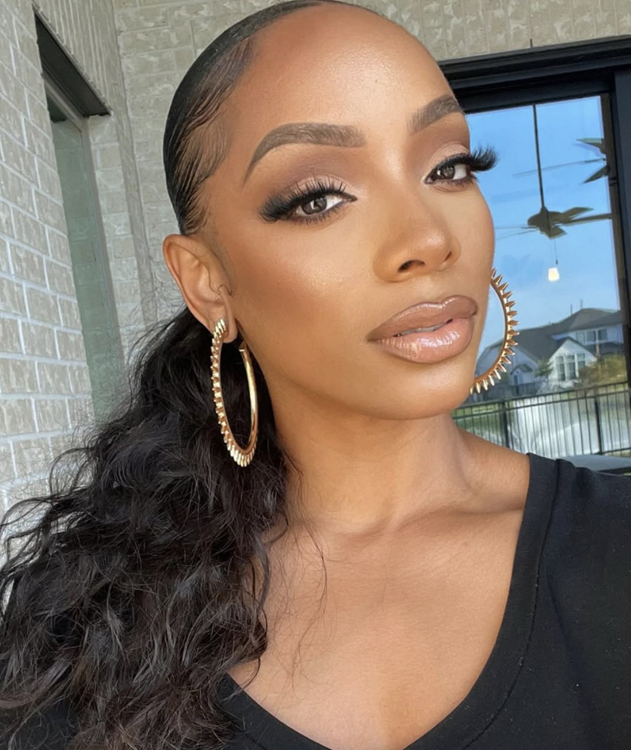 Woman wearing warm gold eye makeup and subtle golden cheek highlight
