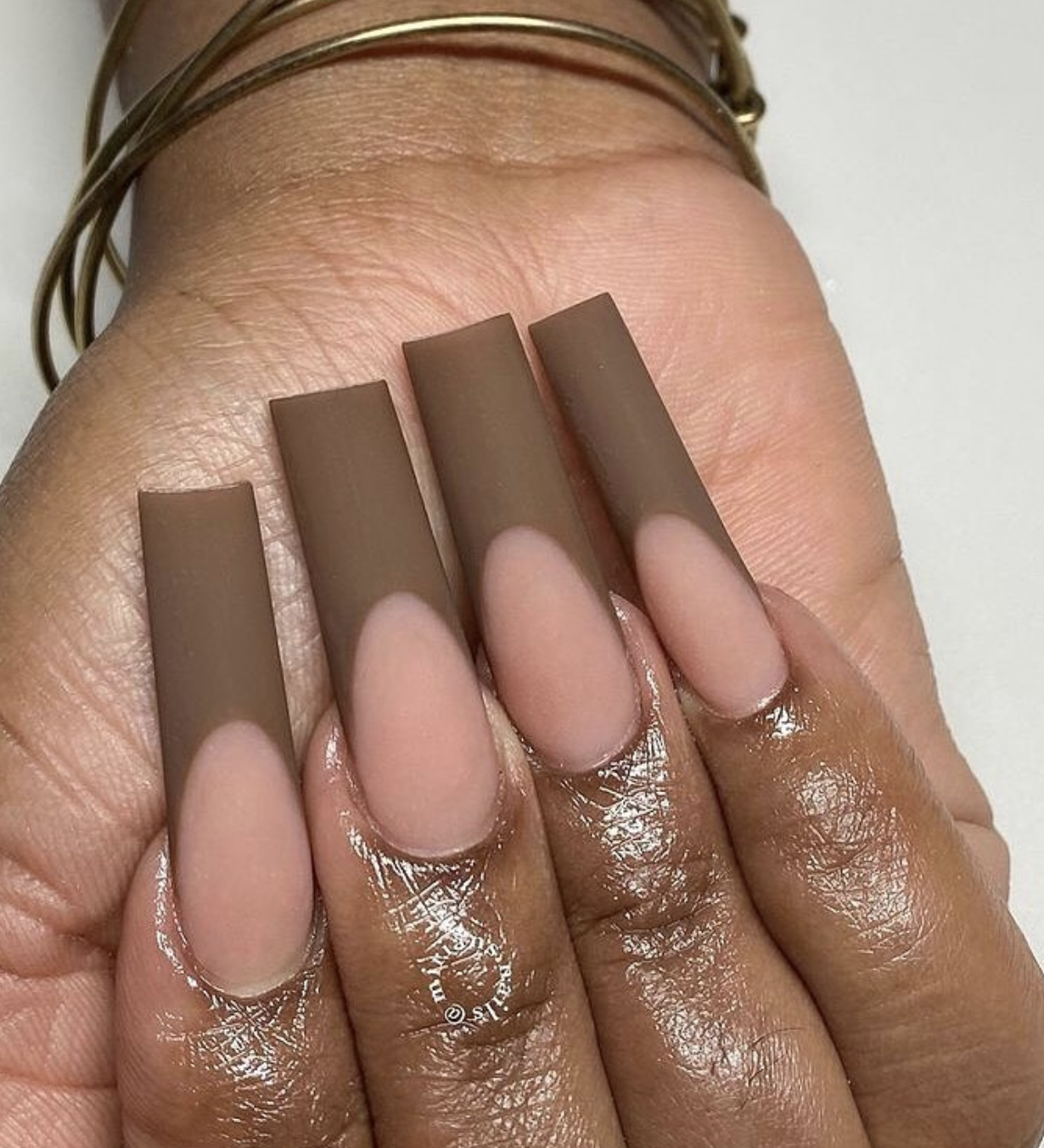 Close-up of matte taupe french on neatly manicured hands