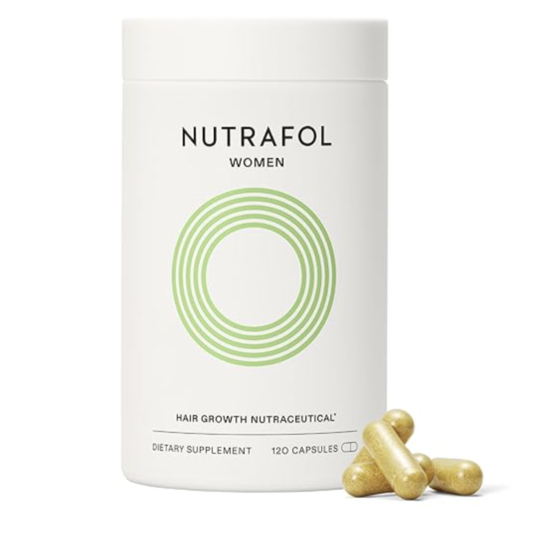 A close-up product shot of a white bottle of Nutrafol Women Hair Growth Nutraceutical dietary supplement, showing the green circular logo and a few gold capsules resting beside it.