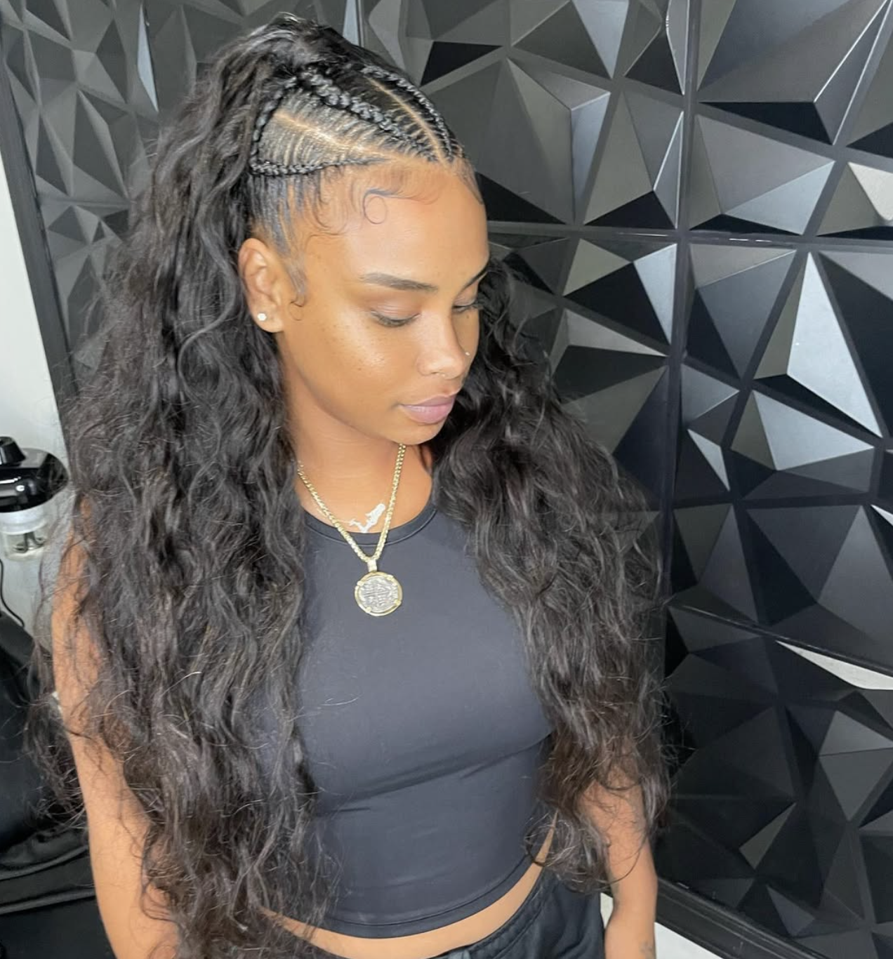 Individual braids styled in a voluminous half-up half-down ponytail.