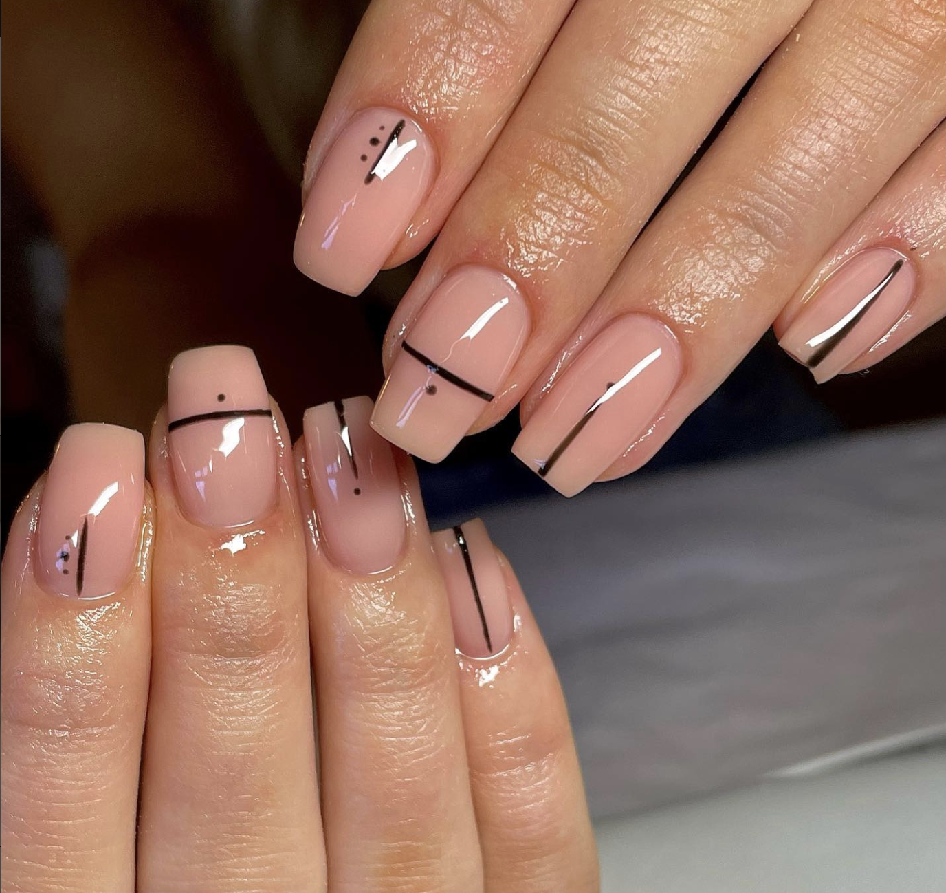 Short natural nails with a sheer pink base and fine black French tips.