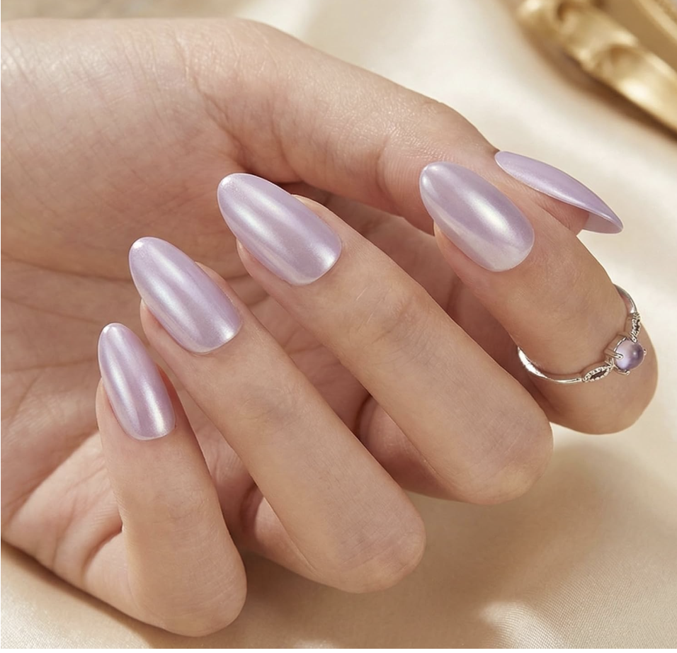 A close-up of a hand showcasing lilac chrome almond press-on nails with a subtle metallic shimmer.