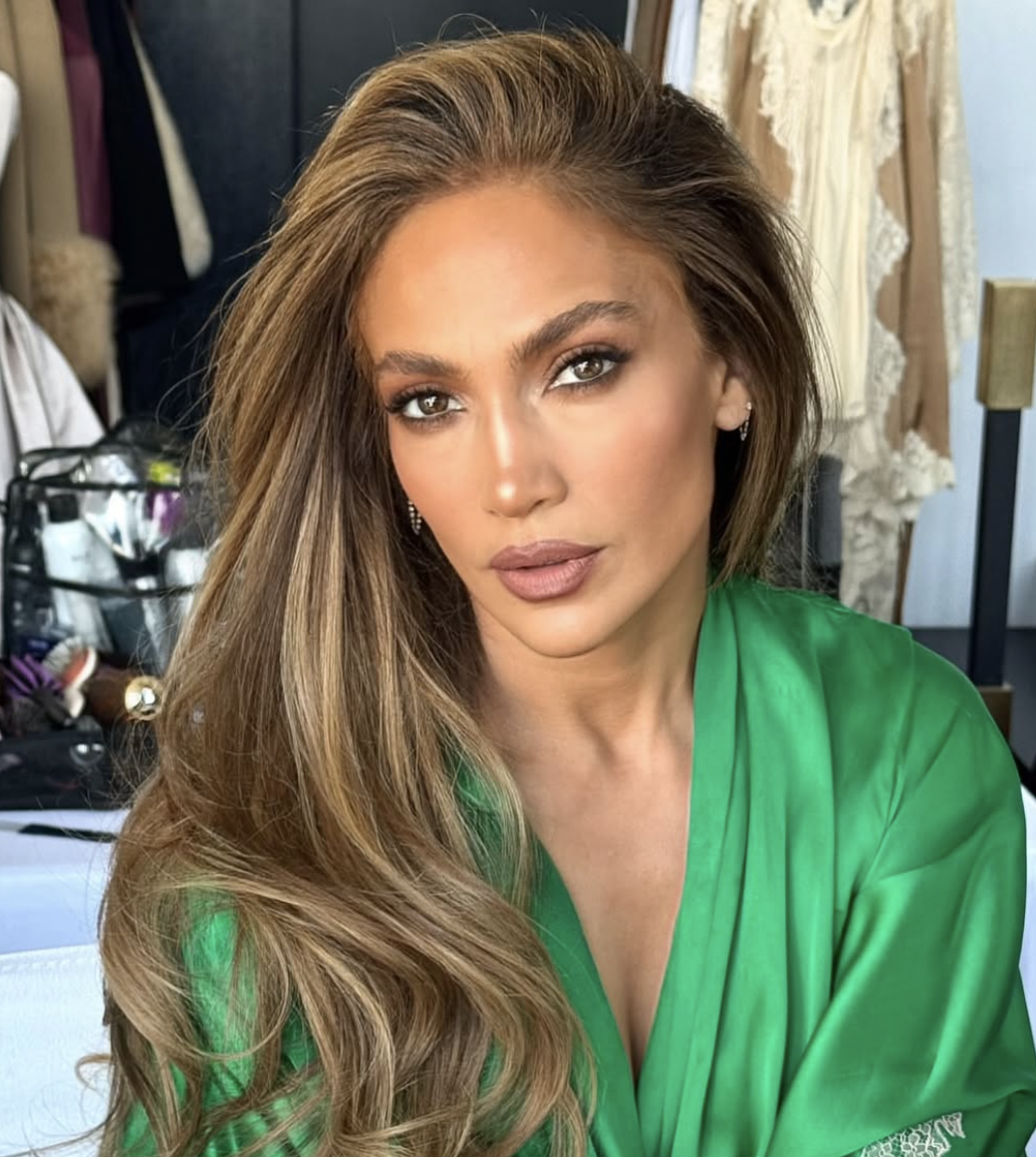 Jennifer Lopez wearing a vibrant grass-green dress, illustrating how bright, warm-toned colors harmonize with a golden-medium complexion in the Light Spring palette.