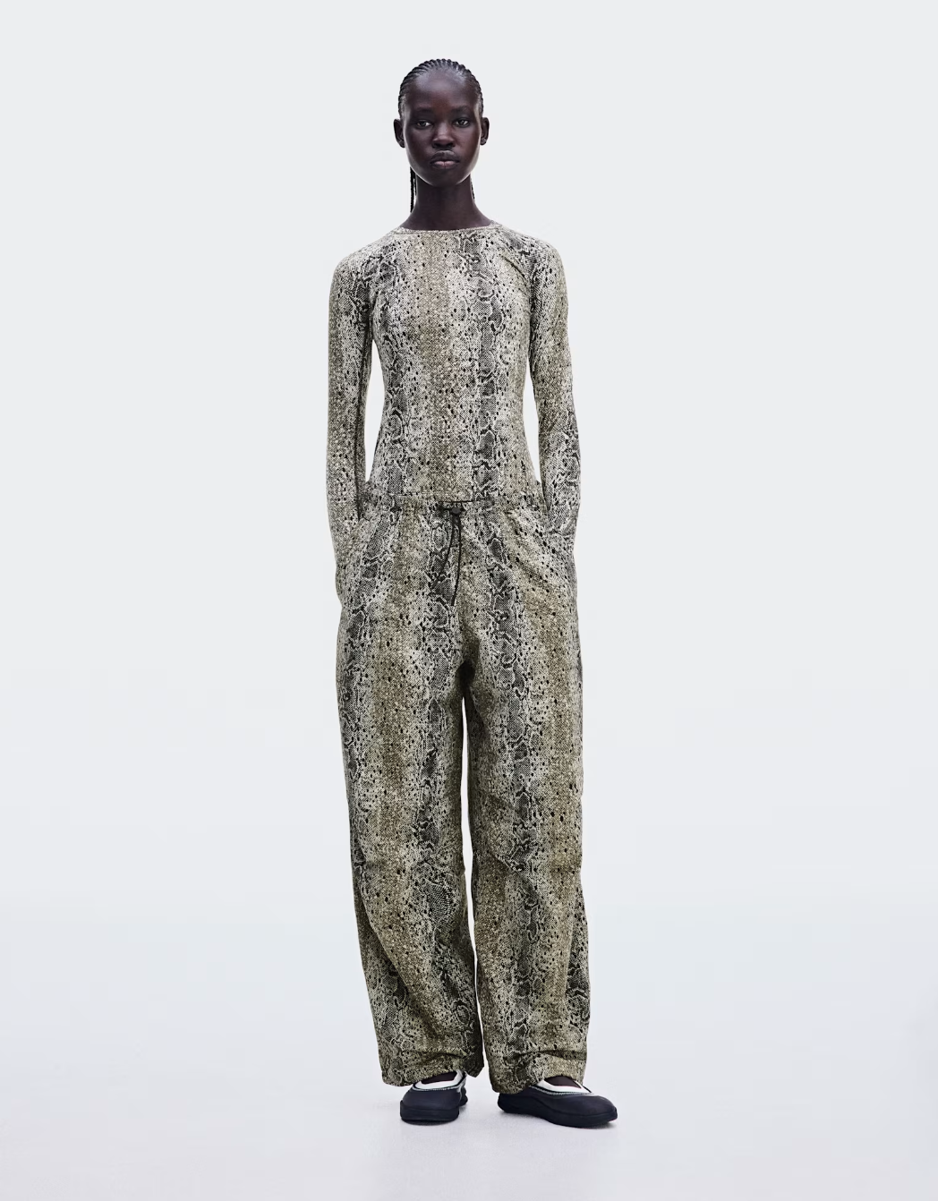 Python-print On parachute pants with adjustable bungee cords at the waist and knees.